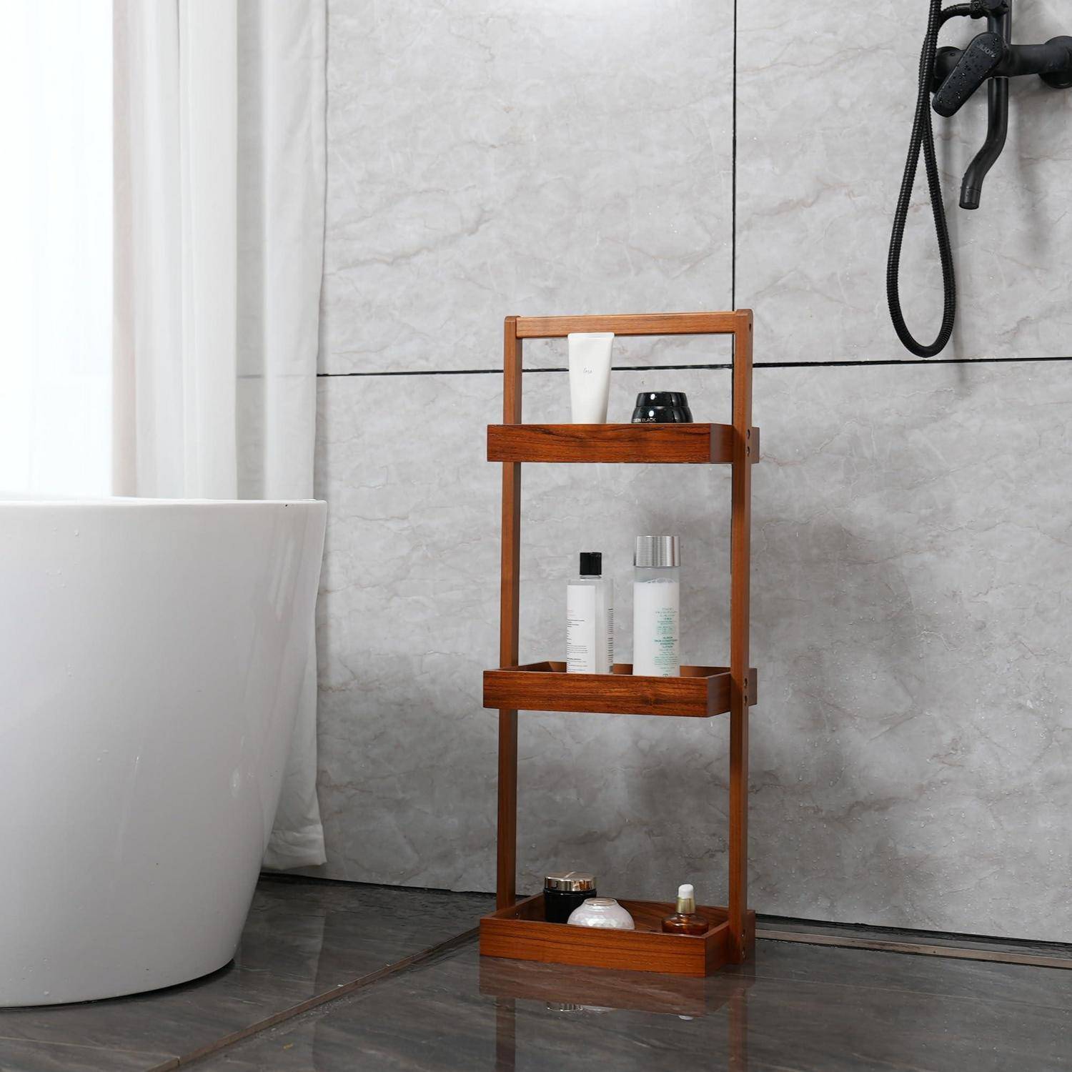 Hölzernes Badezimmerregal neben einer Badewanne mit Toilettenartikeln in Flaschen und Gläsern vor einer grau gefliesten Wand.