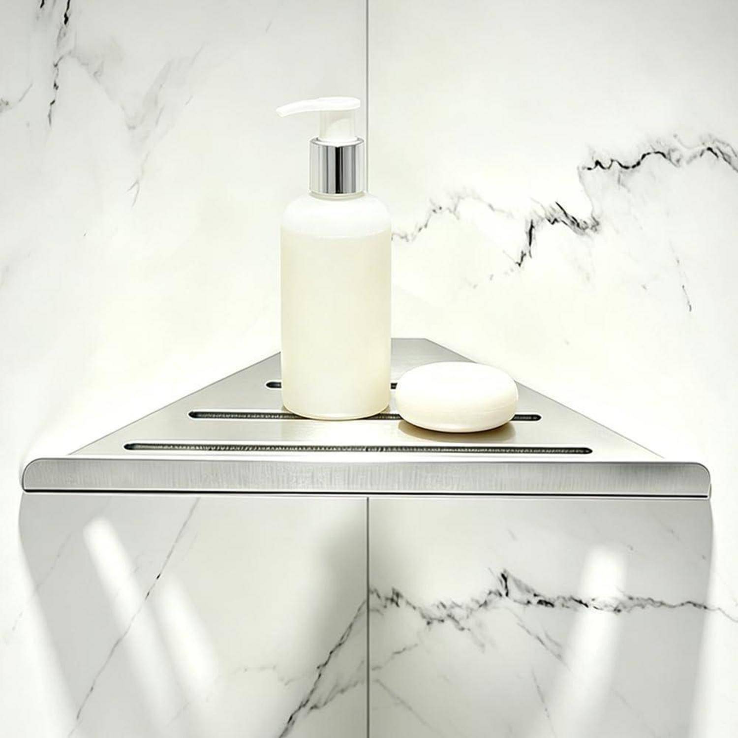 Modernes Chrome-Duschregal mit einer weißen Pumpflasche und einem Seifenstück vor einer Wand mit Marmormuster.