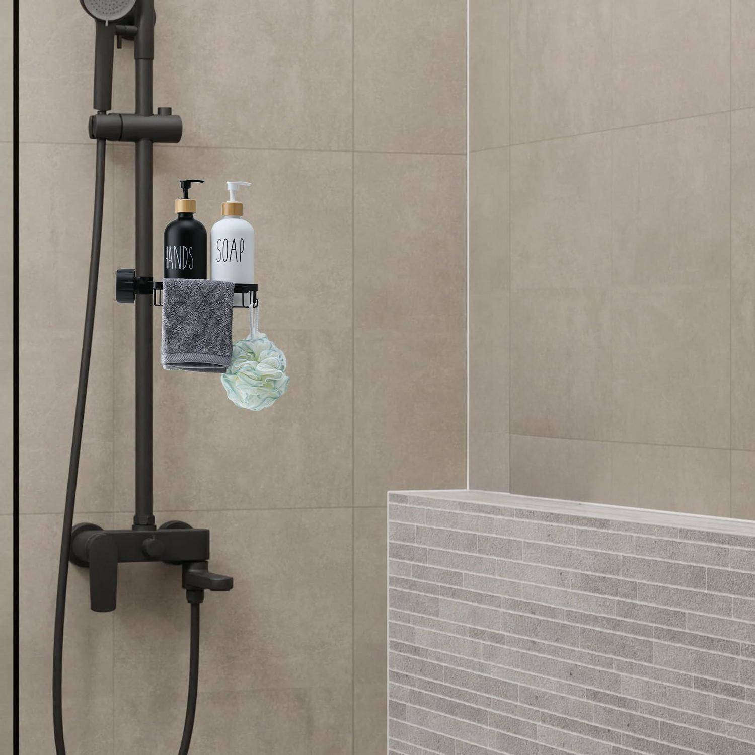 Badezimmerdusche mit schwarzem Armaturenset und Ablage mit „HANDS"- und „SOAP""-Flaschen, Handtuch und Luffa gegen beige Fliesenwand.