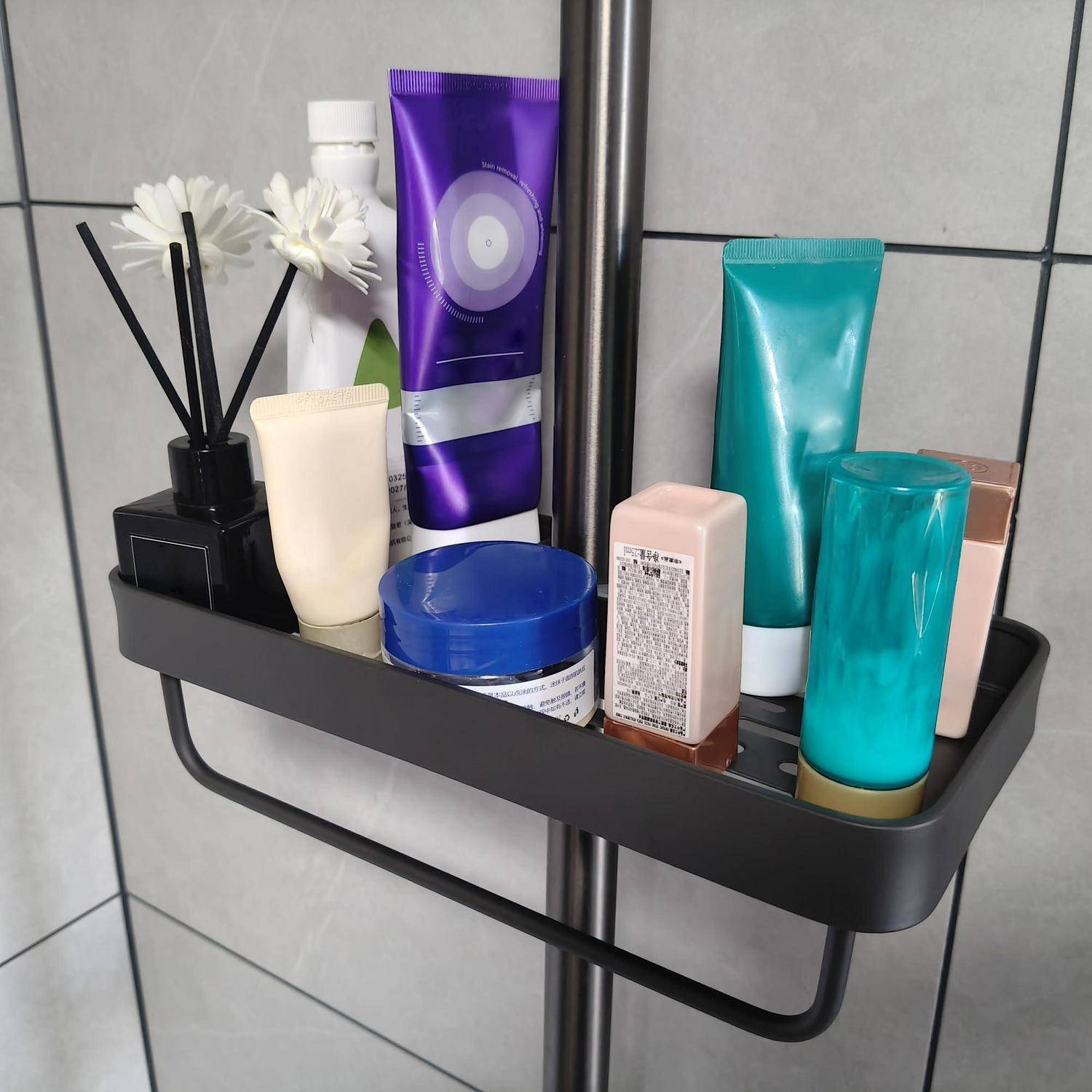 Eckduschregal mit einer Auswahl an Badeprodukten, darunter Tuben, Flaschen und ein Raumduft-Diffusor mit weißen Blüten.