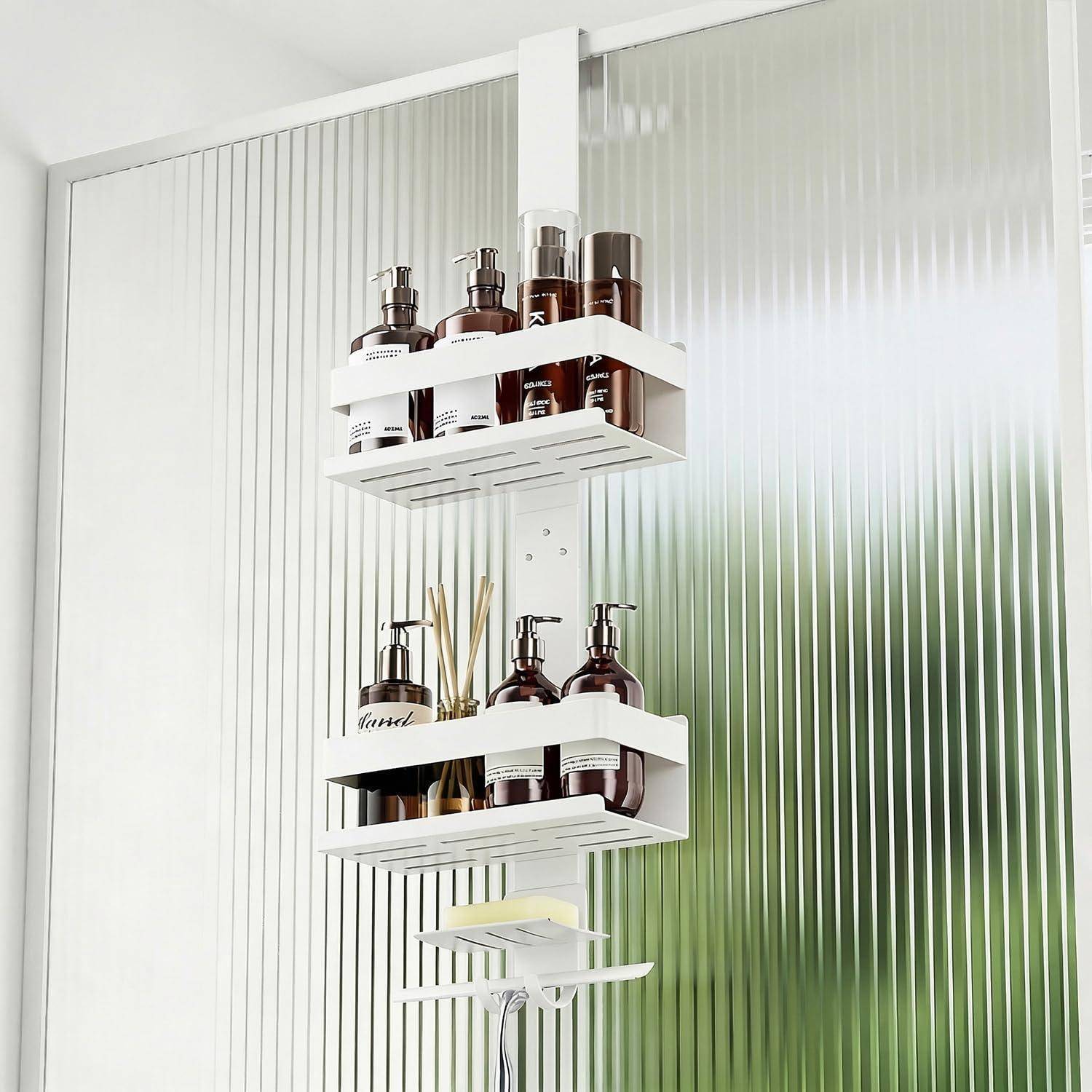 Weiß eloxiertes Dusch-Regal mit zwei Regalen, das bernsteinfarbene Pumpflaschen, Kerzen und Raumduft-Stäbchen an einer mattierten Glasduschenwand hält.