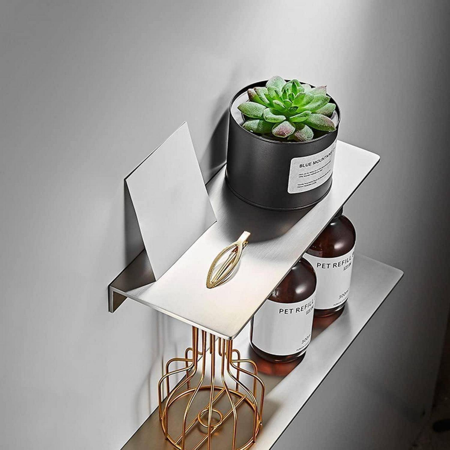 Wandmontiertes Metallregal mit einem Topf-Sukkulente und Glas-Nachfüllflaschen, plus goldfarbenem Drahthalter und Blanko-Kartendisplay.
