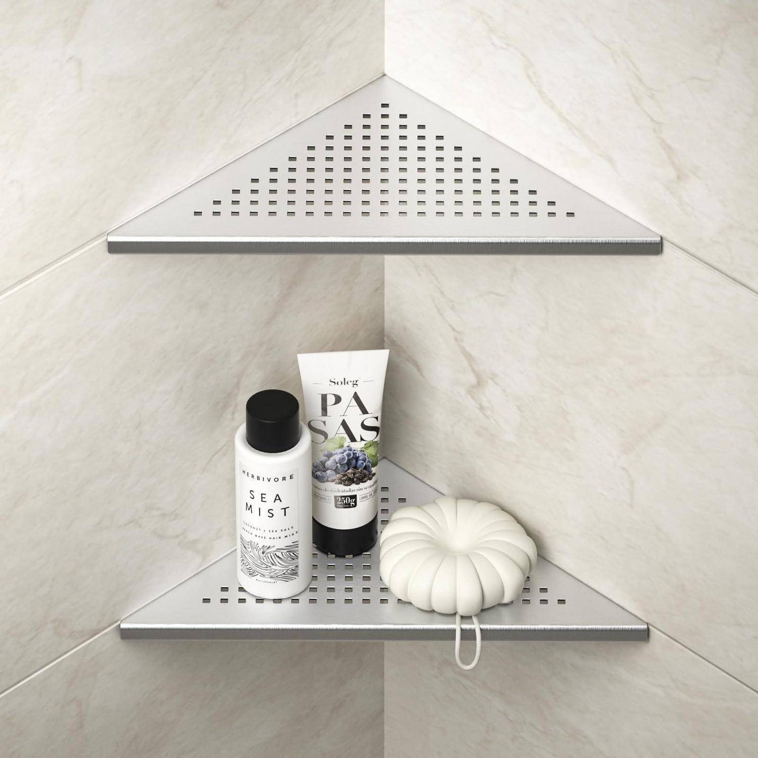 Eckiges Dusch­regal mit einer Flasche Sea Mist, einer Pro­dukt­tube und einer weißen kürbis­förmigen Deko­rations­figur an einer gekachelten Wand.
