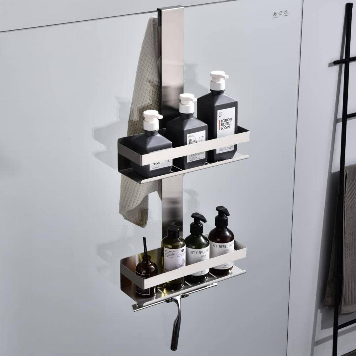 An der Wand montiertes Edelstahl-Badezimmerregal, das Shampoo- und Duschgelflaschen hält, mit einem Haken und einem daneben hängenden Handtuch.