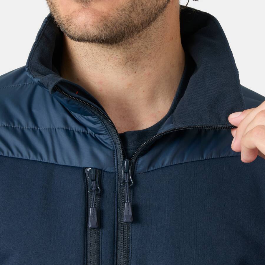 Nahaufnahme eines Mannes, der eine dunkelblaue Jacke mit Reißverschluss trägt und den Kragen offen hält, um den vorderen Reißverschluss und die Brusttasche zu zeigen.