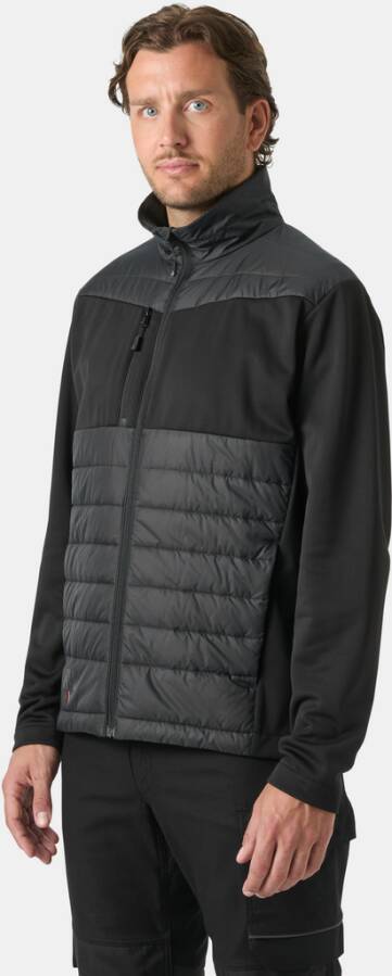 Mann, der eine schwarze Jacke mit Reißverschluss, gesteppten vorderen Paneelen und hohem Kragen trägt, in voller Länge vor einem schlichten Hintergrund gezeigt.