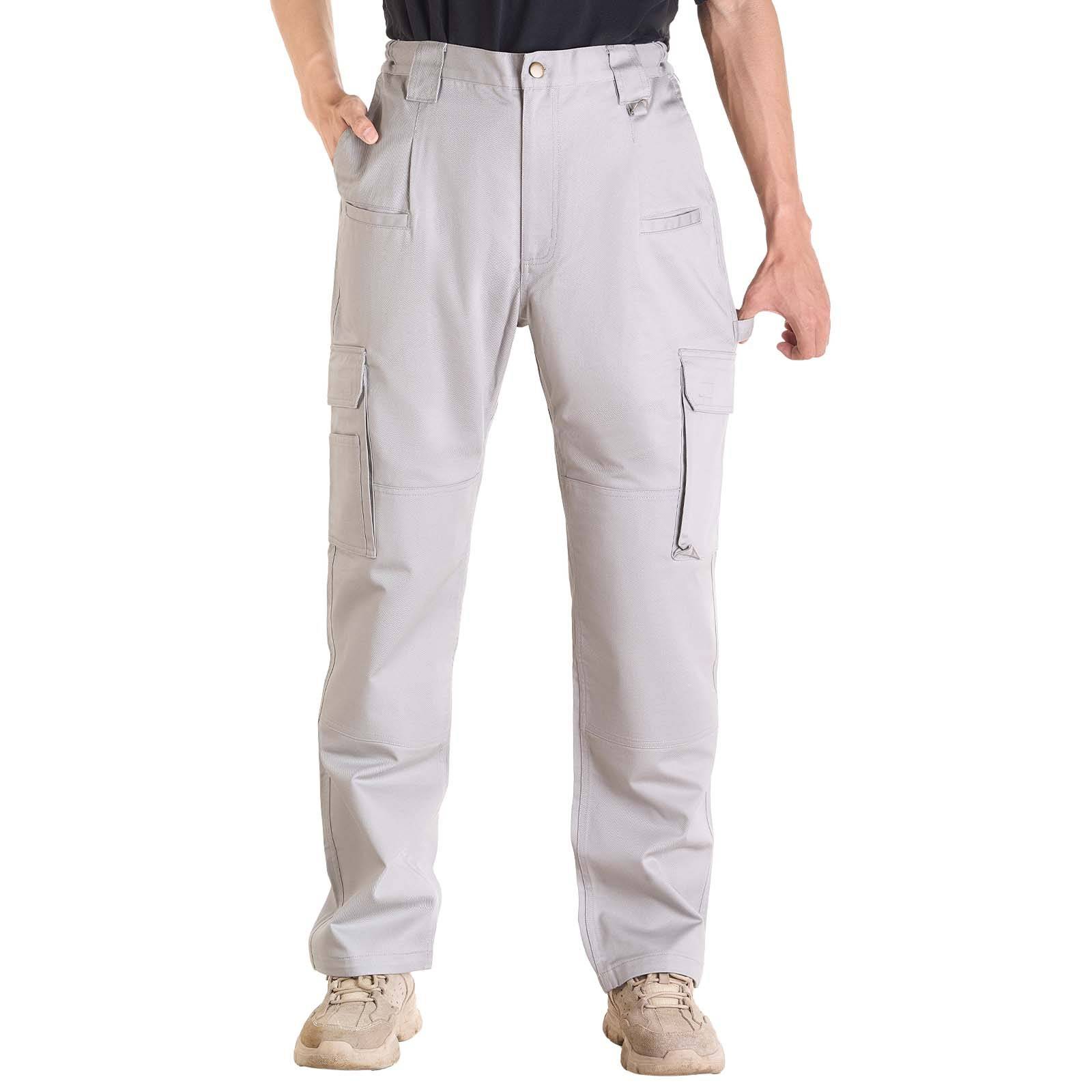 Person trägt hellgraue Cargohose mit mehreren Taschen und beige Sneaker vor weißem Hintergrund.