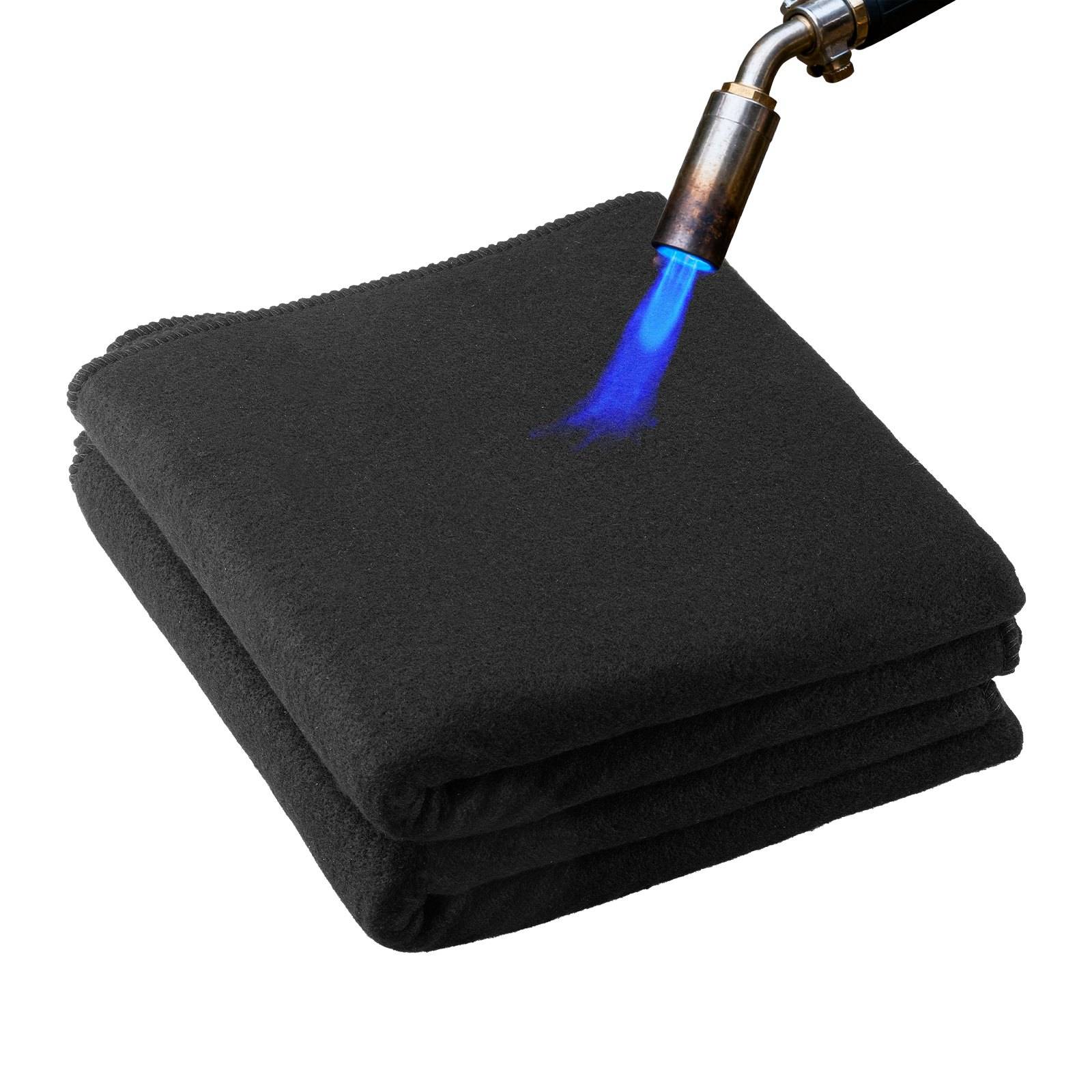 Eine blaue Lötkolbenflamme erhitzt eine gefaltete schwarze Decke oder ein Stoffstück auf weißem Hintergrund und zeigt die Prüfung von feuerbeständigem Material.