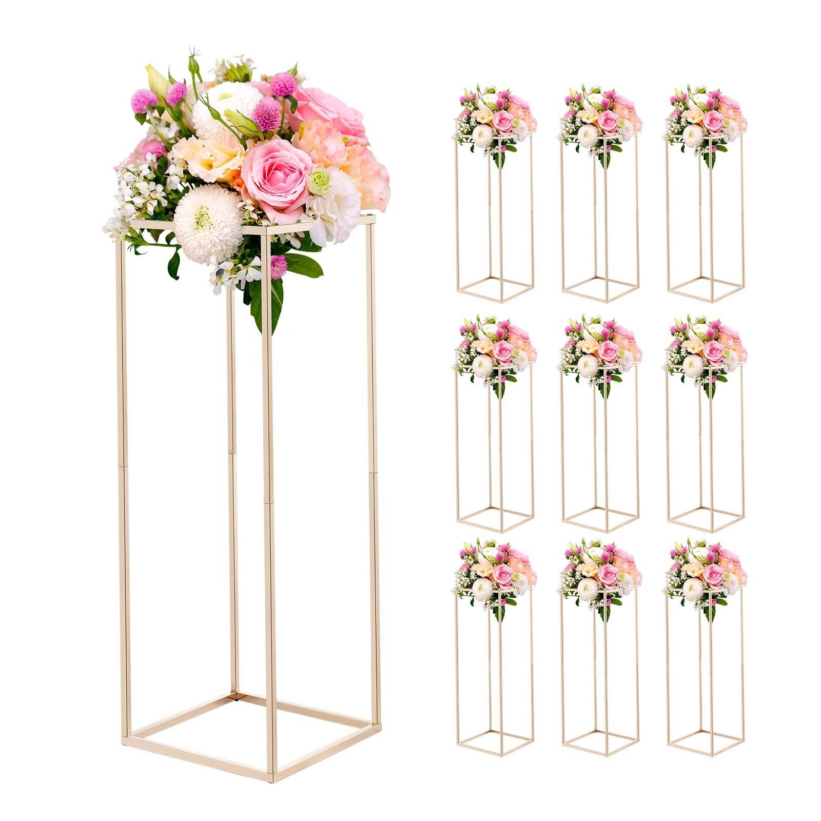 Geometrische Blumenständer aus Gold mit rosa und weißen Blütenarrangements, gezeigt als eine große Ausstellung und mehrere kleinere Versionen.