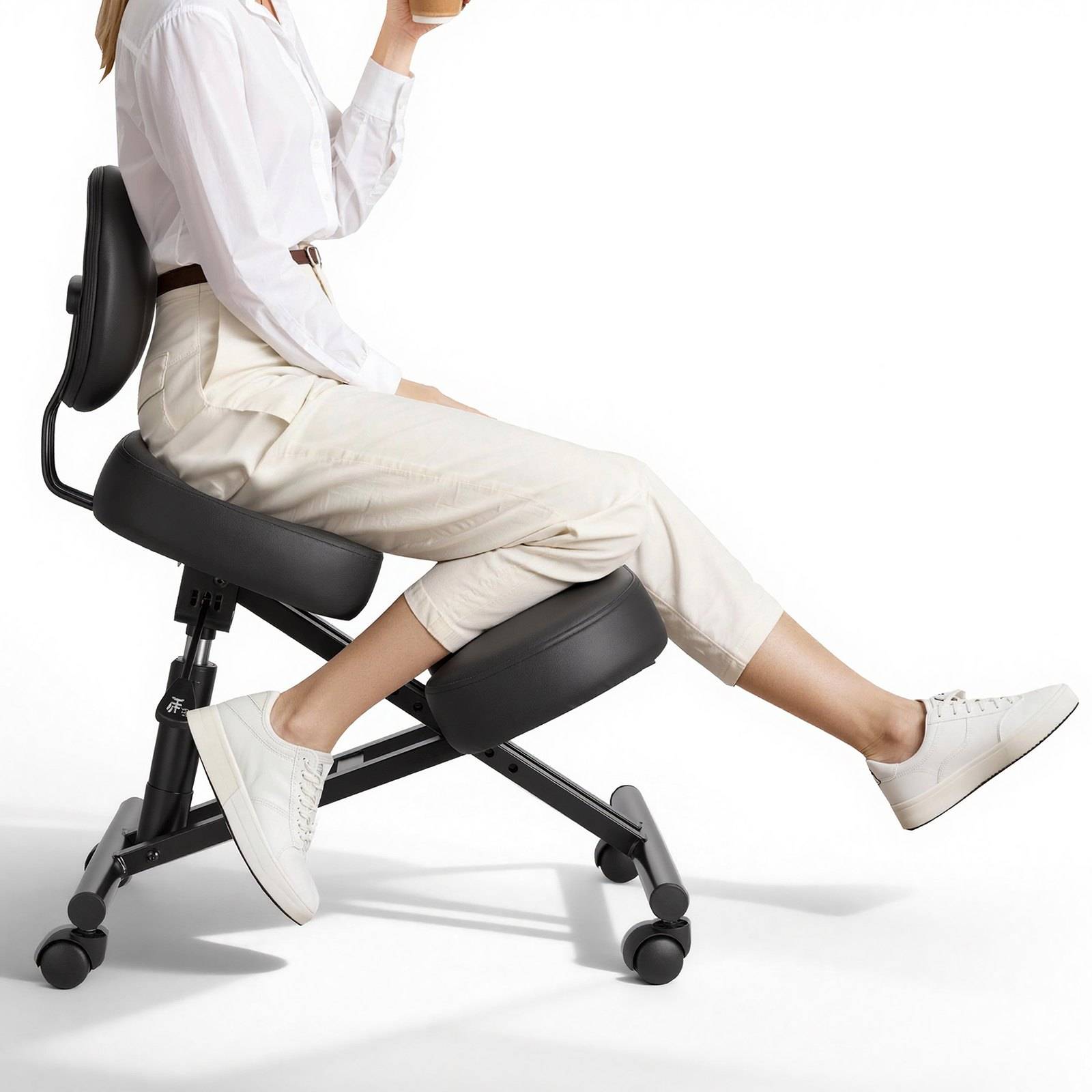 Person, der auf einem schwarzen ergonomischen Kniestuhl sitzt, in Seitenansicht mit ausgestreckten Beinen vor einem einfachen weißen Hintergrund gezeigt.