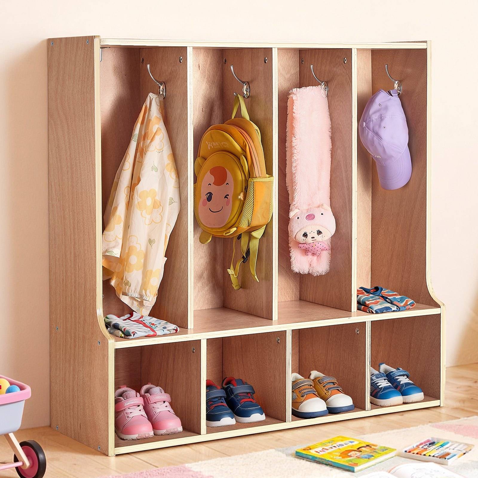 Holz-Kinderschrank mit Hängefächern und Schuhfächern, in dem Mäntel, Rucksäcke, Mützen und mehrere Paar Kinderschuhe aufbewahrt werden.