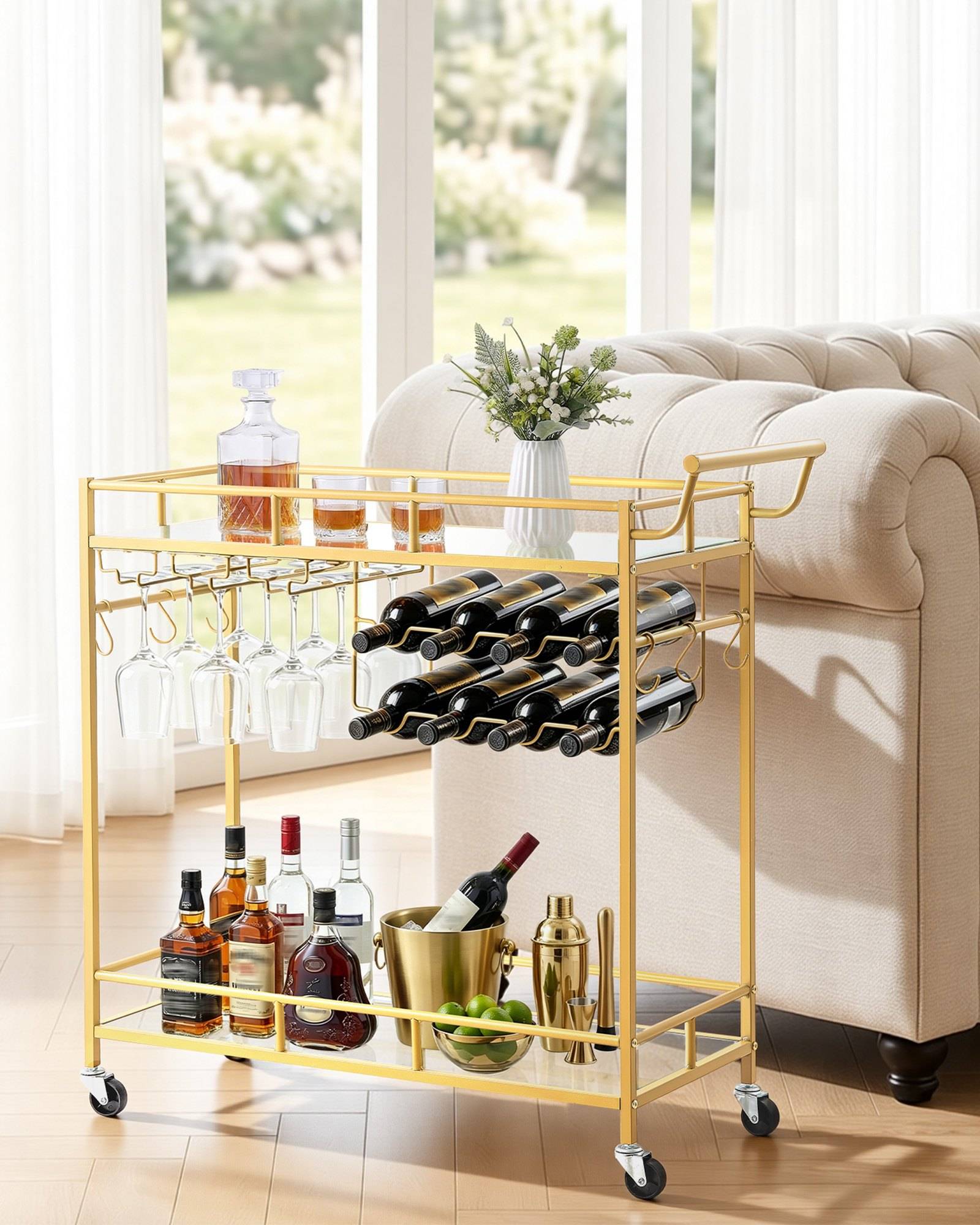 Goldener fahrbarer Barwagen mit Weinflaschen, hängenden Gläsern und Cocktailwerkzeugen neben einem beigefarbenen Sofa in einem hellen Wohnzimmer.