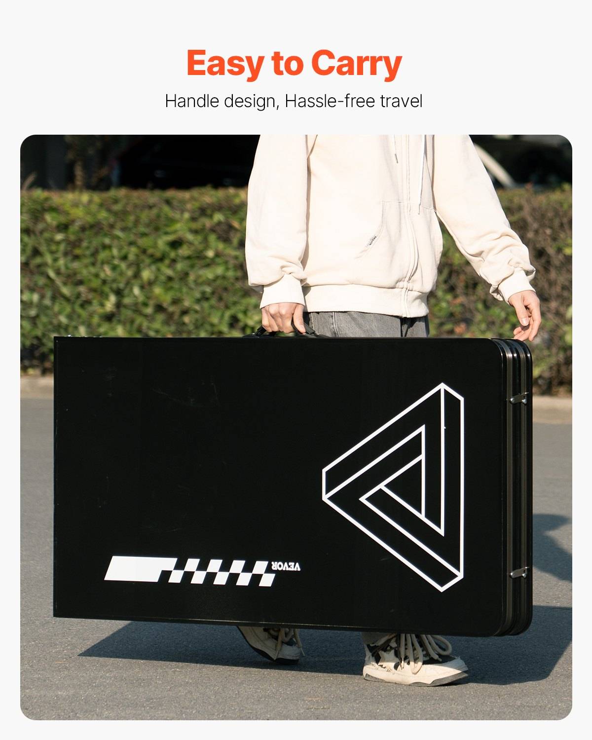Person mit einem großen schwarzen Koffer mit integriertem Griff, beschriftet mit "Leicht zu tragen"" und ""Griffdesign, Sorgenfreies Reisen"".