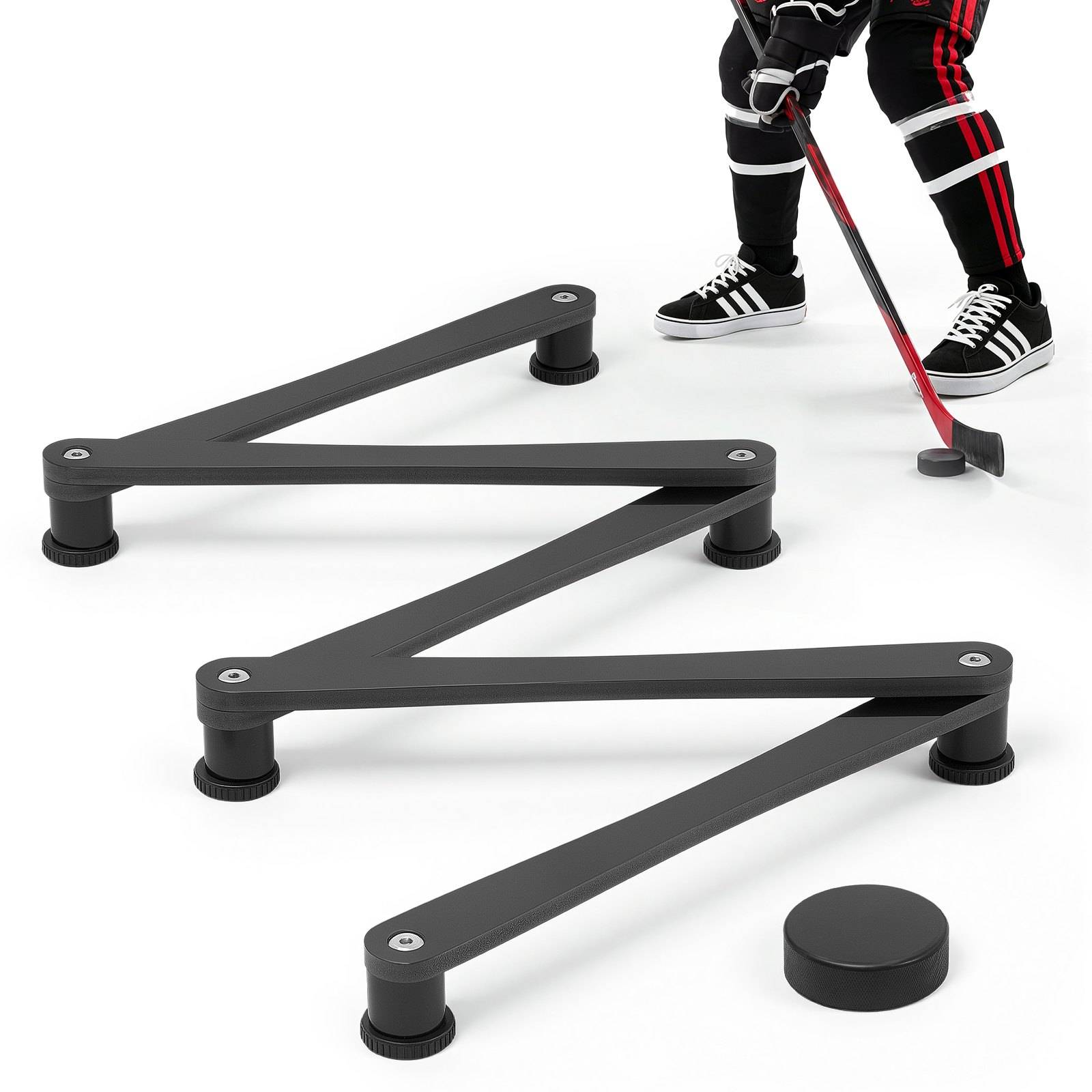 Verstellbare Hockeybande mit Zickzack-Armen in Schwarz auf weißem Boden, neben einem Spieler mit Schläger und Puck.