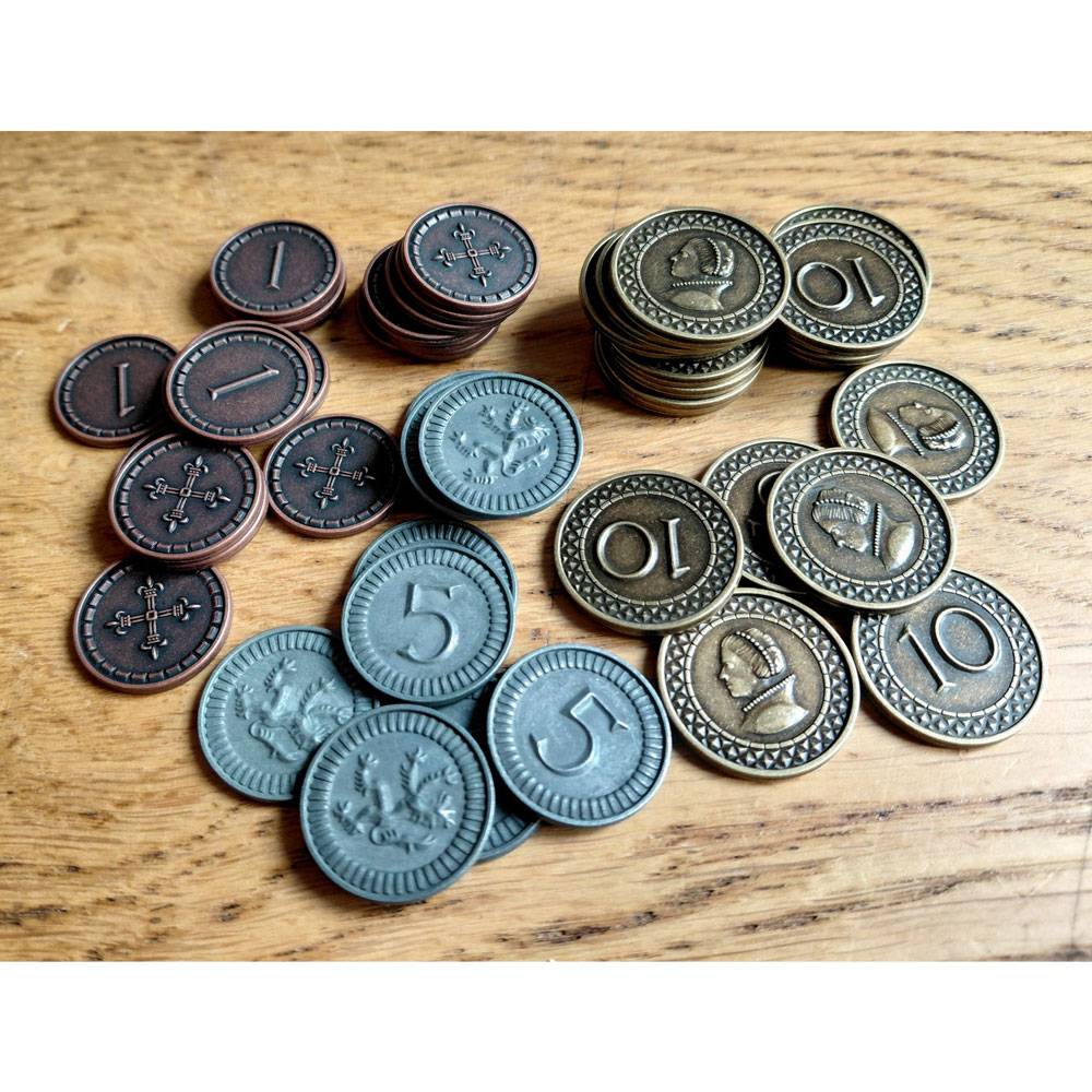 Drei Stapel runder Spielmarken auf einer Holzoberfläche: dunkelbraune 1er, blaue 5er und bronzefarbene 10er mit geprägten Symbolen.