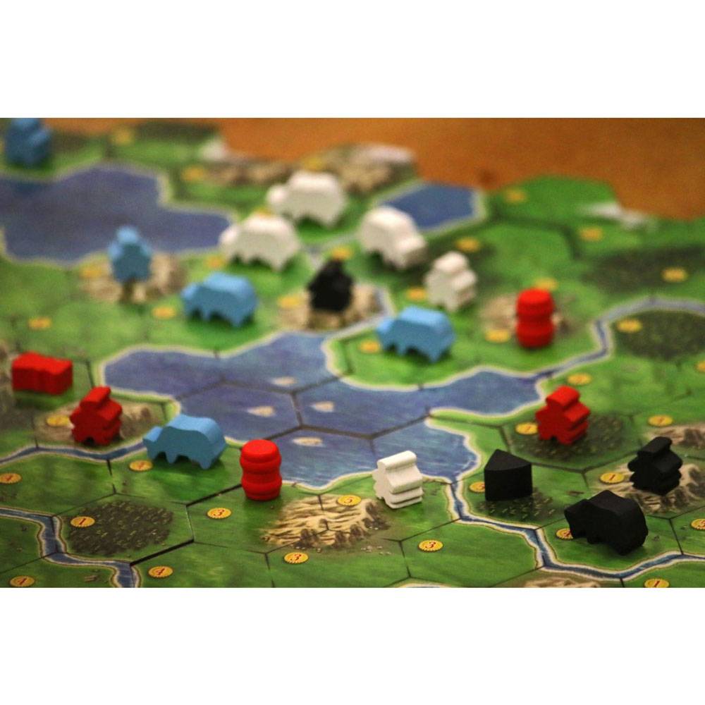 Nahaufnahme einer Brettspielkarte mit farbigen Kunststofffiguren und Häusern auf sechseckigen Land- und Wasserkacheln.