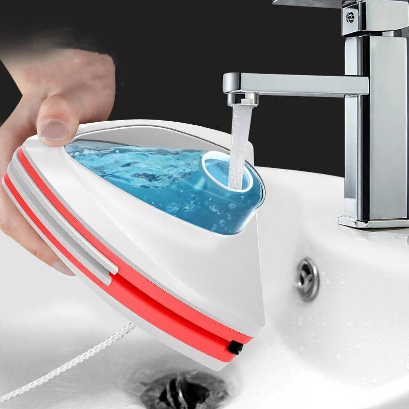 Tragbares Dampfbügeleisen wird aus einem Badezimmerhahn über einem Waschbecken mit Wasser gefüllt.
