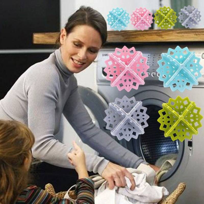 Eine Frau lädt Wäsche in eine Frontlader-Waschmaschine, während ein Kind in der Nähe zeigt; bunte Schneeflocken-Dekorationen sind oben angebracht.