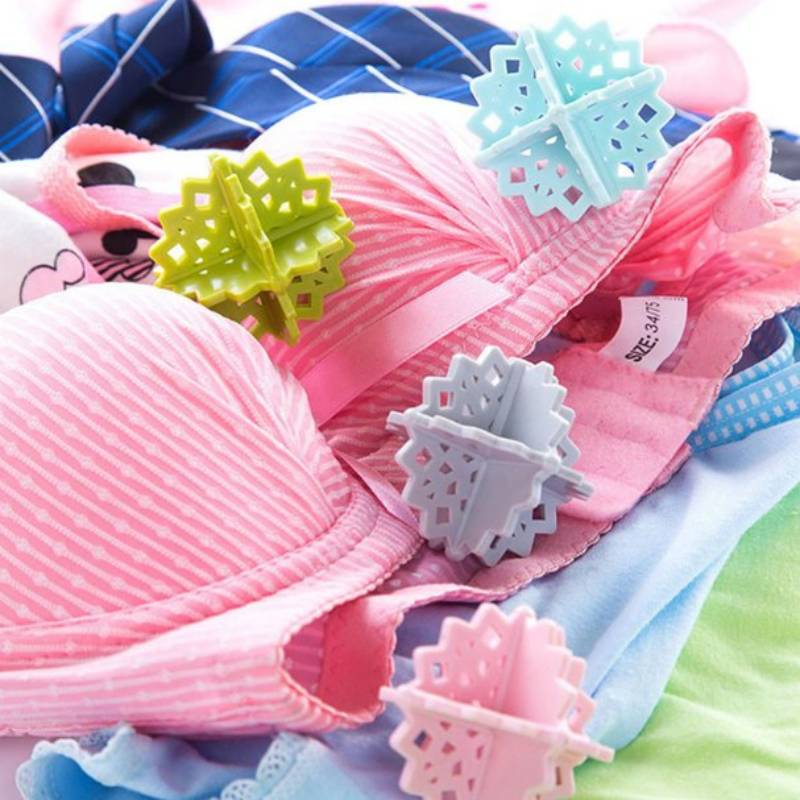 Haufen bunter BHs mit dekorativen schneeflockenförmigen Clips auf den Trägern, dargestellt in einem produktorientierten Nahaufnahmefoto.