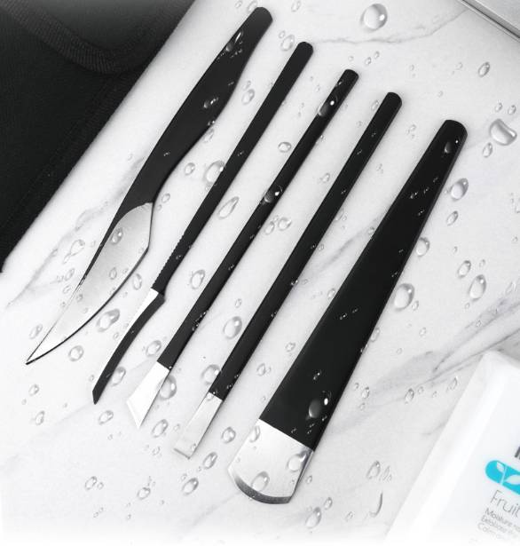 Fünf schwarze und silberne Makeup-Pinsel diagonal auf einer nassen weißen Oberfläche mit Wassertropfen angeordnet.
