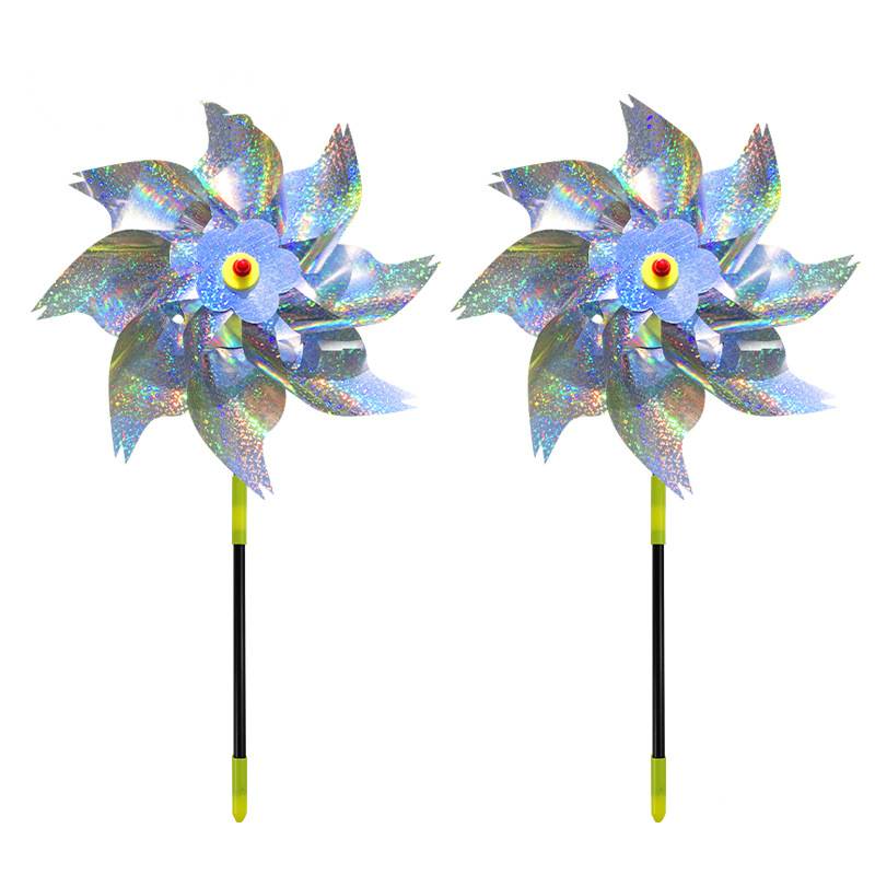 Zwei schillernde Windmühlen-Gartenstecker mit blauen Blütenmittelpunkten und gelb gespitzten schwarzen Stielen auf weißem Hintergrund.