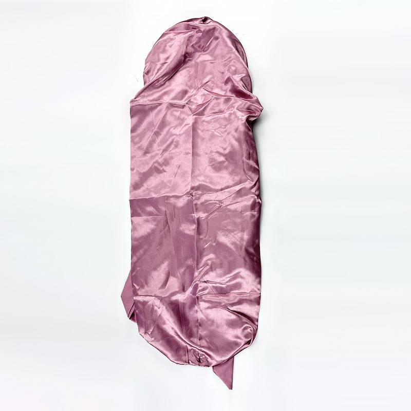 Rosa Satinschlafsack oder Stoff-Hülle flach auf weißem Hintergrund ausgebreitet.