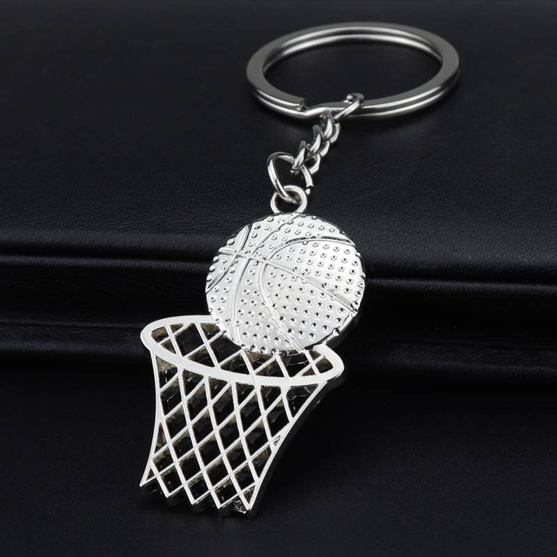 Silberner Basketball-Schlüsselanhänger mit einem Reifen und Ballanhänger auf schwarzem Hintergrund.