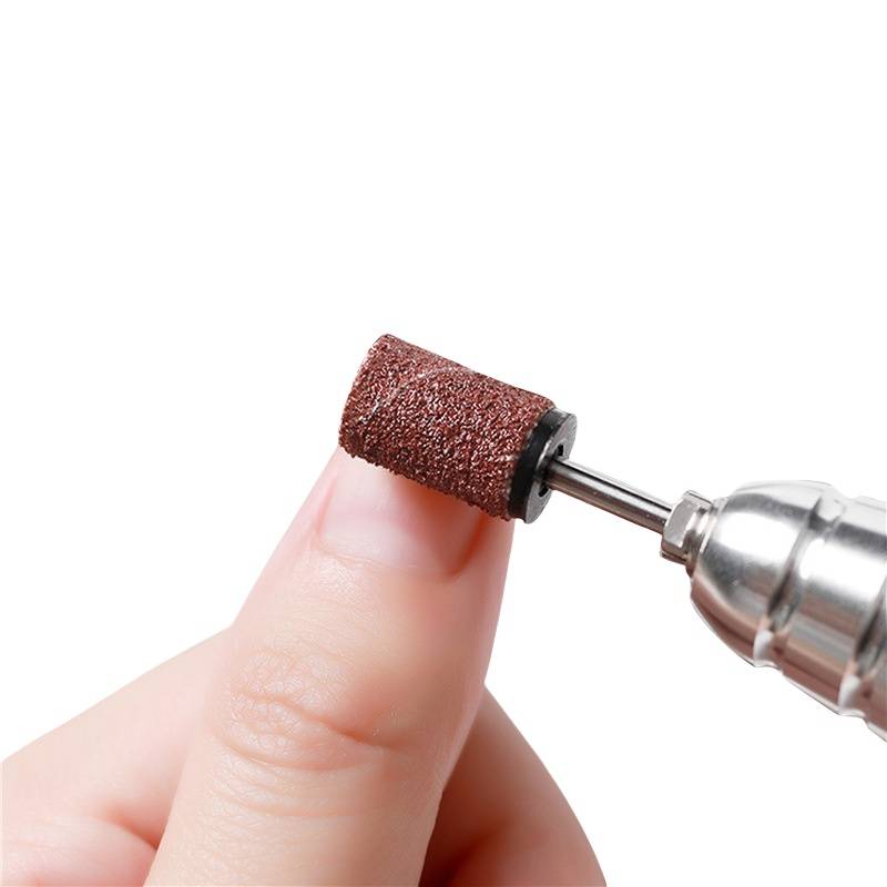 Ein rotierender Nagelbohrer feilt sanft einen Fingernagel mit einem Schleifbit.