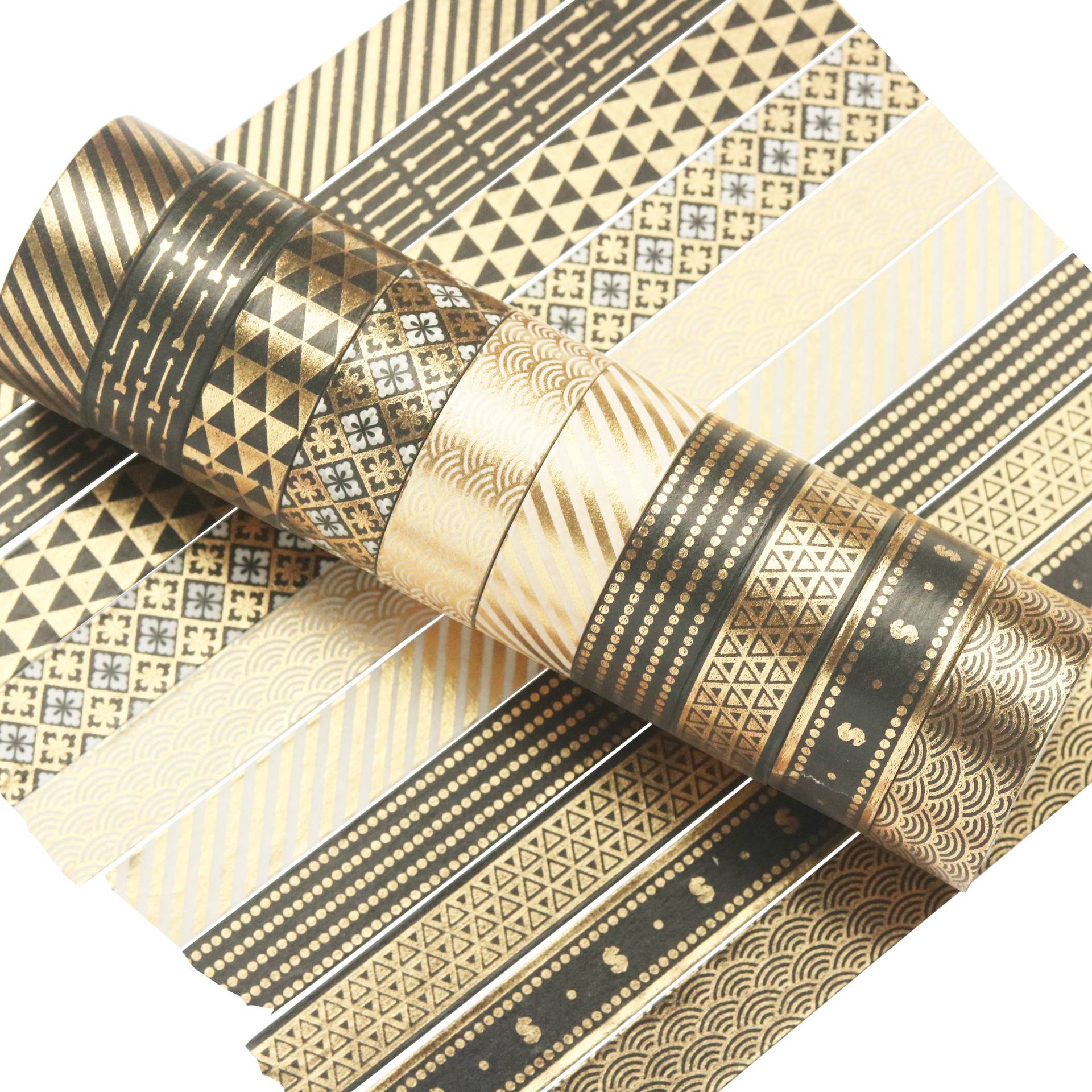 Aufgerollte dekorative Washi-Tapes in Gold und Schwarz mit Muster, mit mehreren darunter angeordneten passenden geometrischen und metallischen Streifen.
