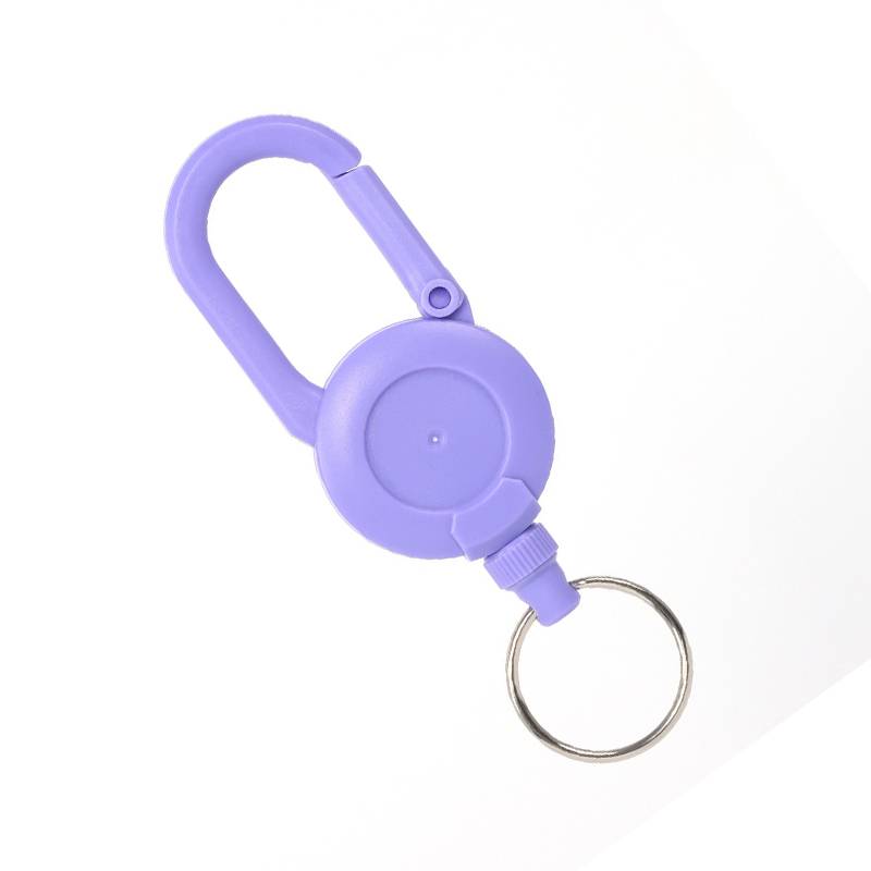 Violetter Karabiner-Schlüsselanhänger mit ausziehbarer Spule und Metallschlüsselring auf weißem Hintergrund.