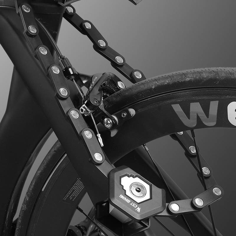 Nahaufnahme eines Fahrradrades und Rahmens mit einem Faltscharnierungsmechanismus, der Metallpivotgelenke und eine Radsperre oder Nabe zeigt.