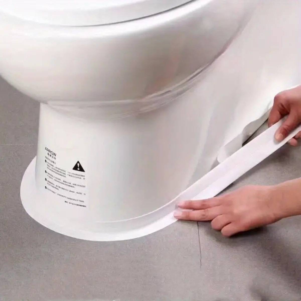 Hände kleben weißes Klebeband um die Basis einer Toilette auf einem Fliesenboden an und versiegeln die Toilette auf dem Boden.