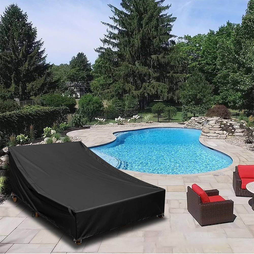 Hinterhof-Terrasse mit einem überdachten Liegestuhl neben einem freiformigen blauen Schwimmbecken, umgeben von Steinbelag, roten Stühlen und Bäumen.
