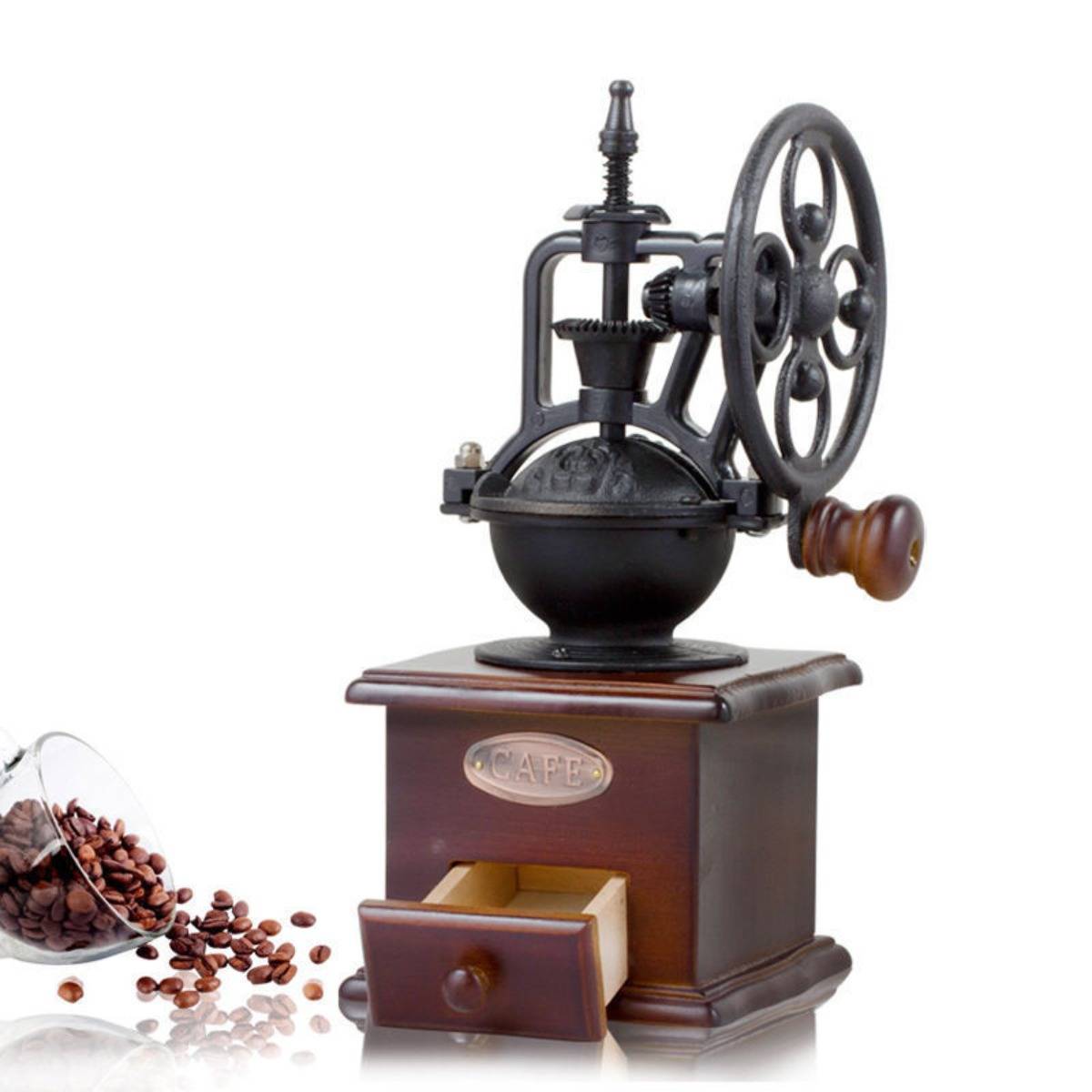 Antike manuelle Kaffeemühle mit Holzsockel und Schublade, gezeigt mit verschütteten Kaffeebohnen daneben auf weißem Hintergrund.