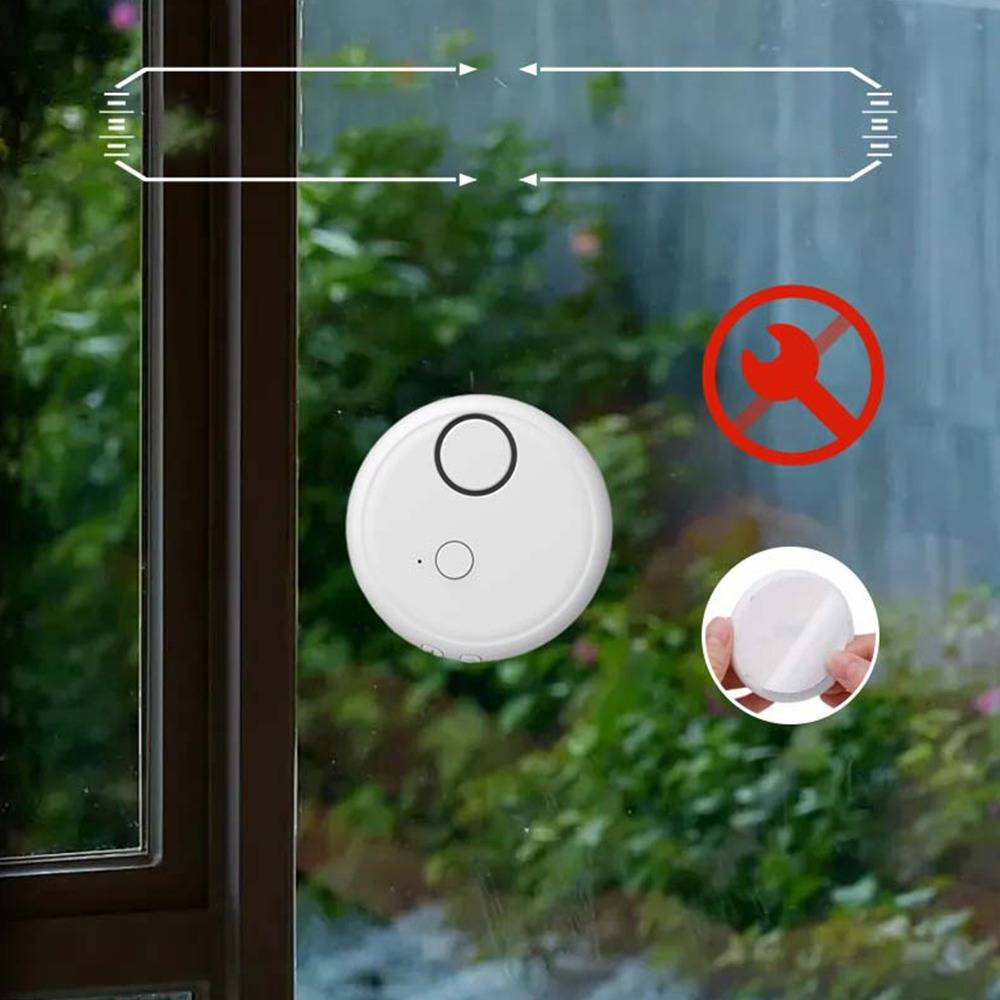 Weißer runder Fensteralarm-Sensor auf einer Glasscheibe, mit rotem durchgestrichenem Schraubenschlüssel-Symbol und einer Detailansicht zur Handmontage, die eine einfache Installation ohne Bohren anzeigt.