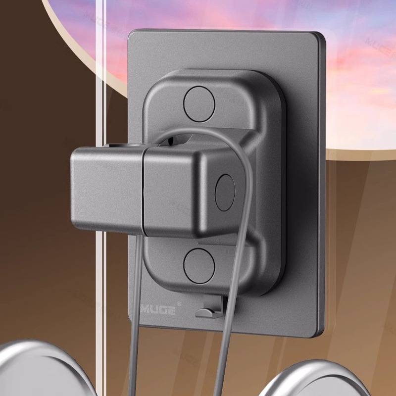 Nahaufnahme eines an der Wand montierten grauen Stromstecker-Adapters oder Ladegeräts mit angeschlossenem Kabel.