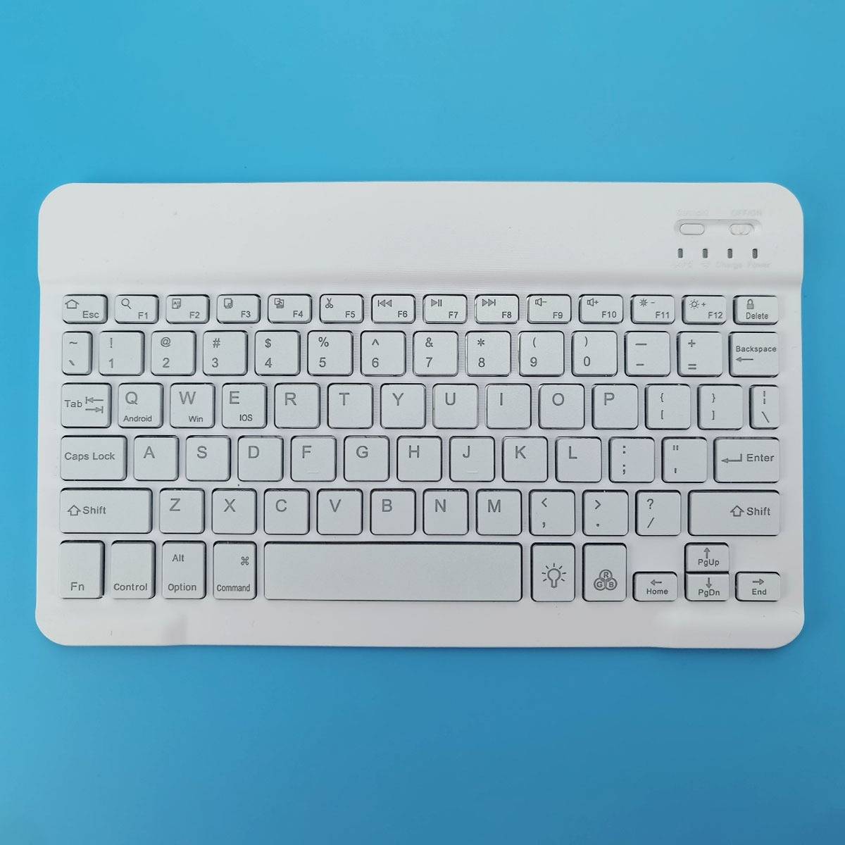 Weiße schnurlose Tastatur von oben auf blauem Hintergrund abgebildet, mit kompakten Tasten und sichtbarer Funktionsleiste.