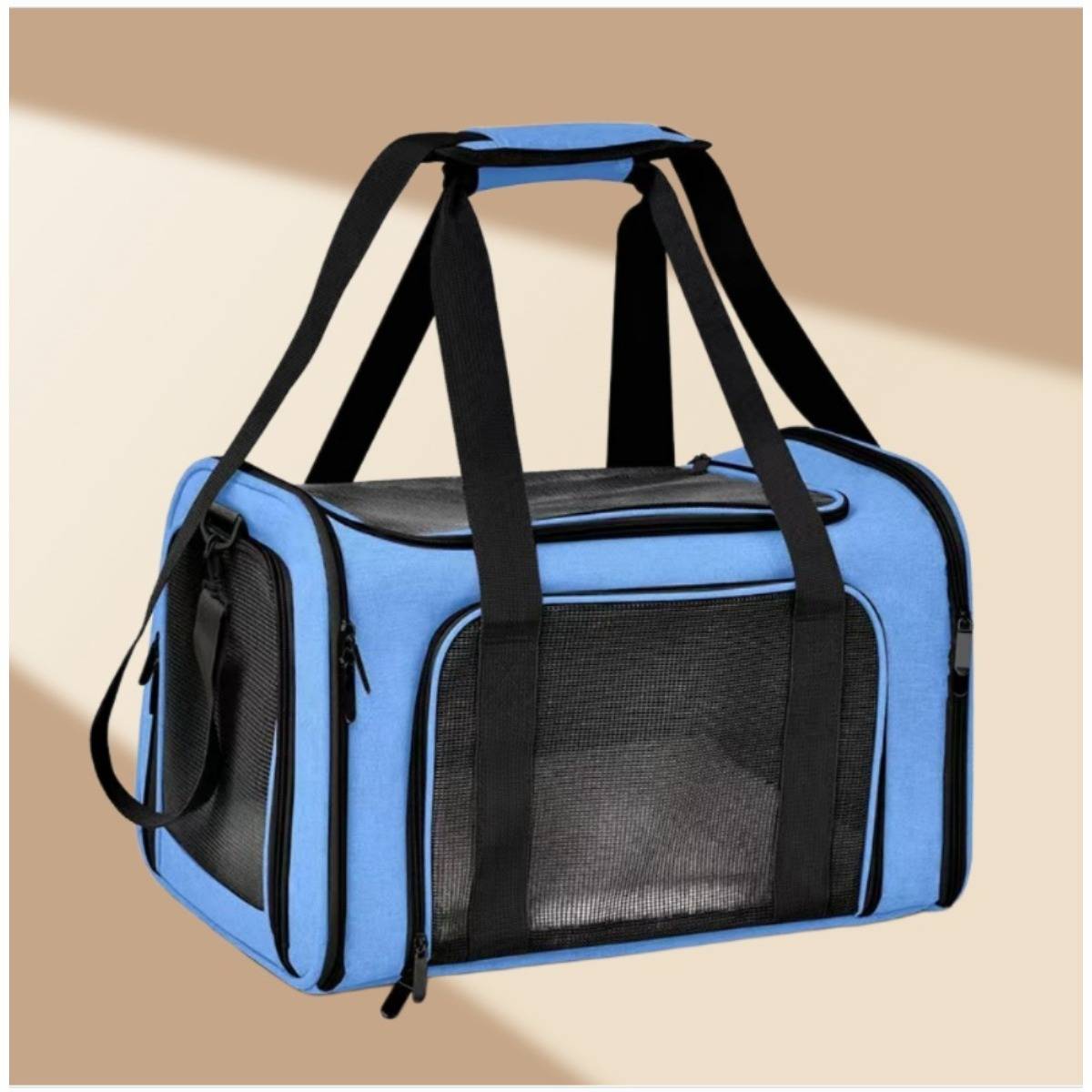 Blauer Haustier-Transportbeutel mit schwarzen Netzpaneelen, Seitentasche und Schultergurten auf beigefarbenem Hintergrund.
