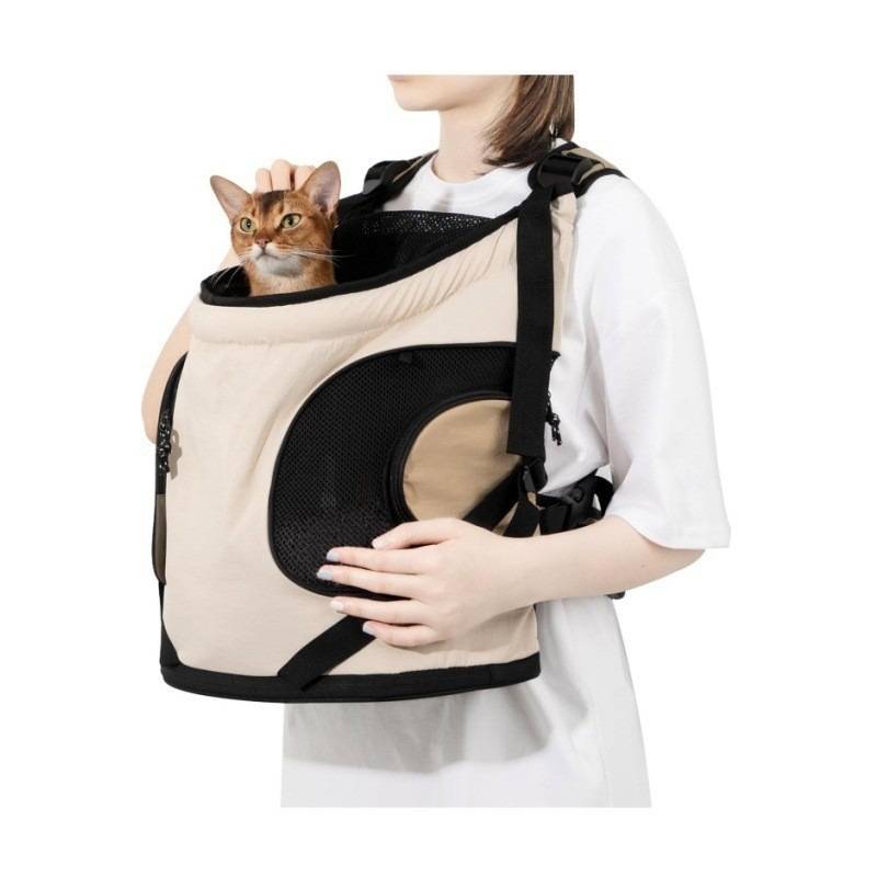 Person trägt einen beigen vorderen Haustier-Tragerucksack mit einer Katze, die aus der oberen Öffnung herausschaut.