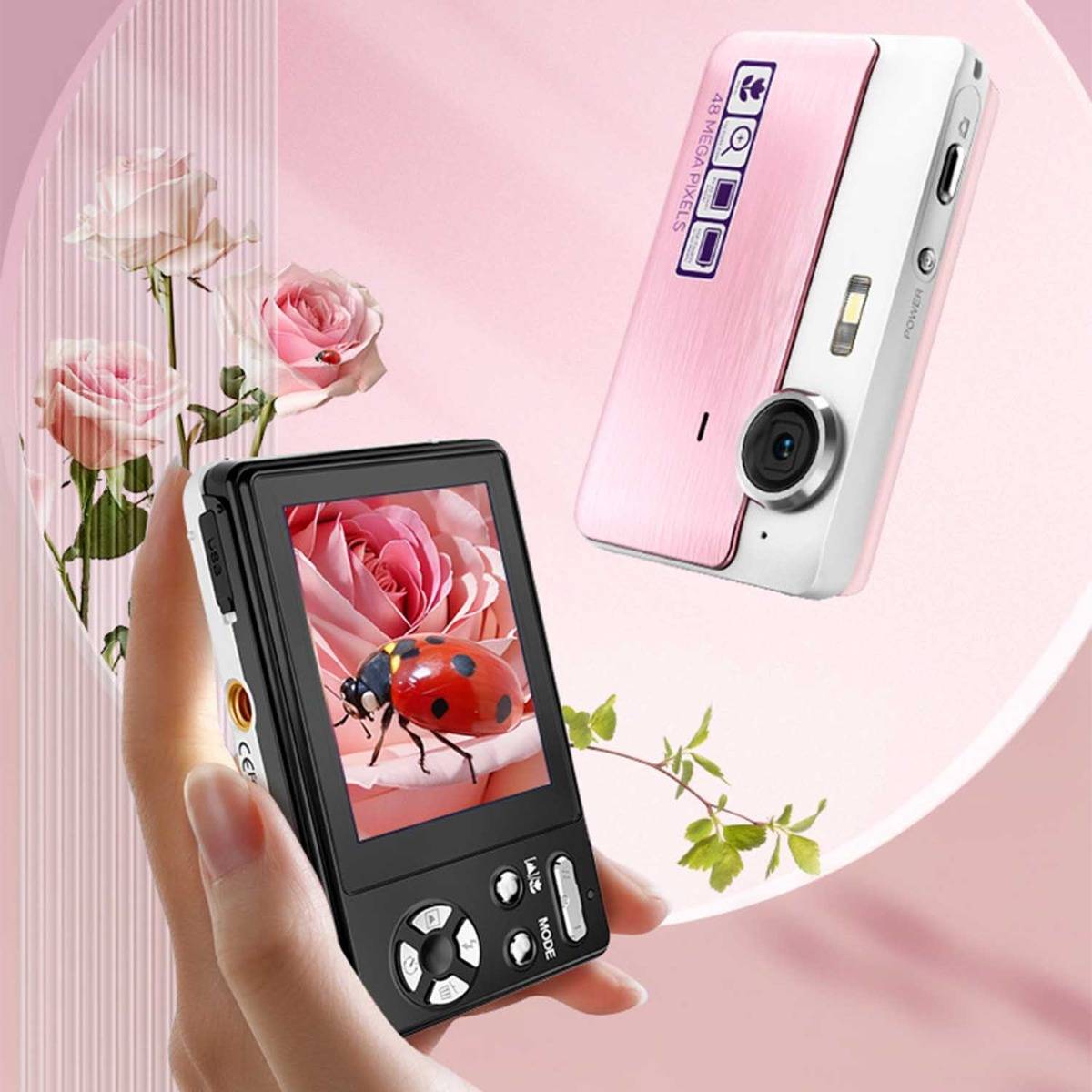 Zwei kompakte digitale Kameras in Schwarz und Rosa, eine in einer Hand gehalten, die einen Marienkäfer auf dem Bildschirm zeigt, vor einem blumigen rosa Hintergrund.