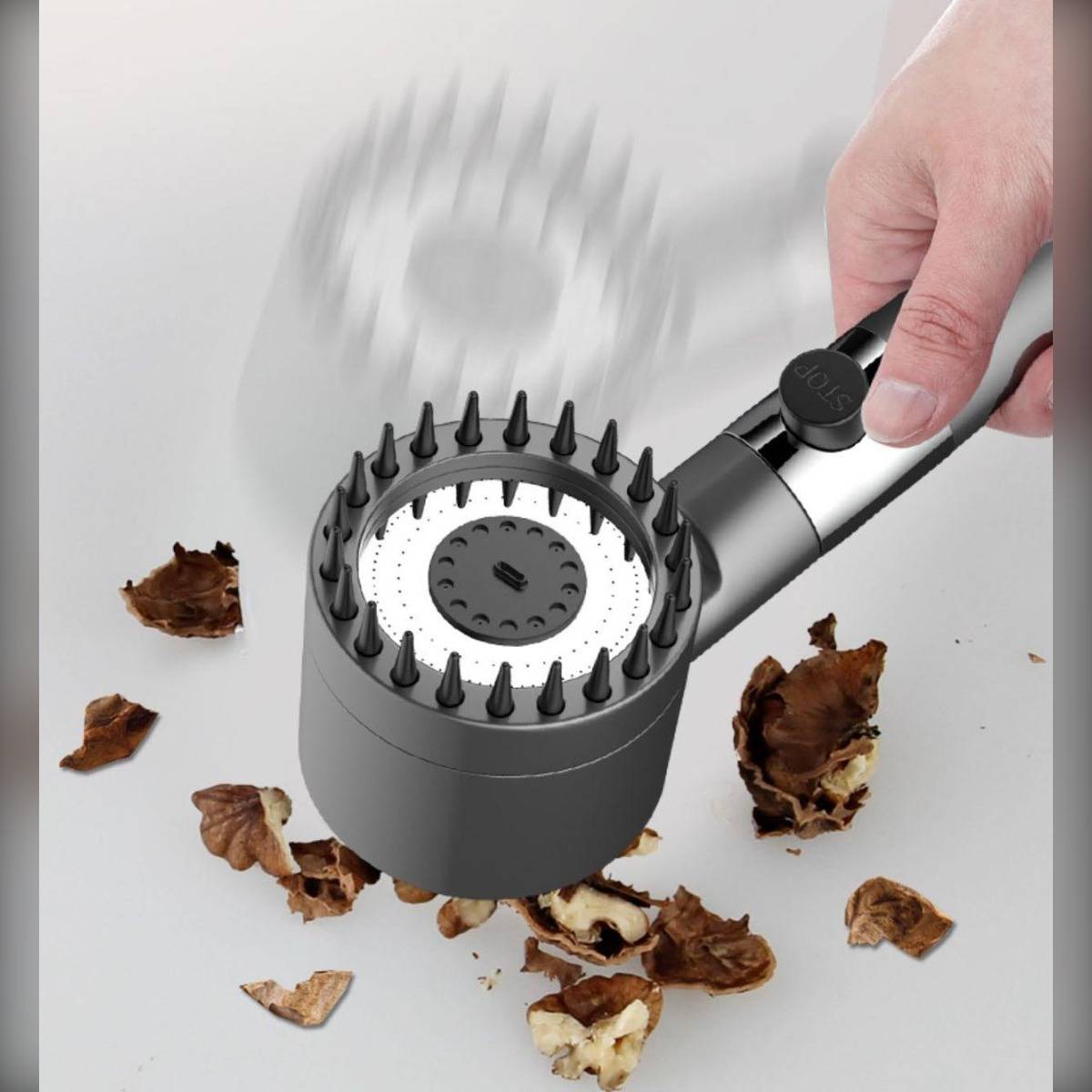 Tragbarer Staubsauger mit Bürstenaufsatz reinigt getrocknete Blätter und Schmutz von einer weißen Oberfläche.