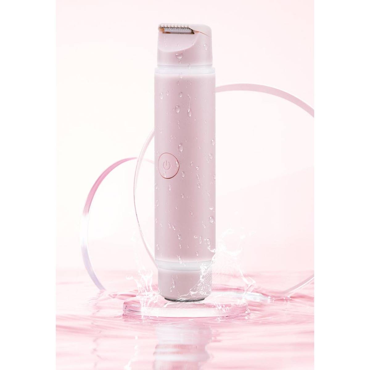 Rosa elektrischer Rasierer stehend im Wasser, mit Spritzern und kreisförmigem Hintergrund, was auf ein wasserdichtes Grooming-Gerät hindeutet.