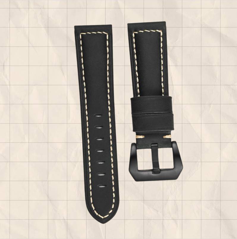 Schwarzes Lederarmband mit weißer Naht und mattschwarzem Verschluss, dargestellt mit dem abgelösten Armband, das daneben liegt.