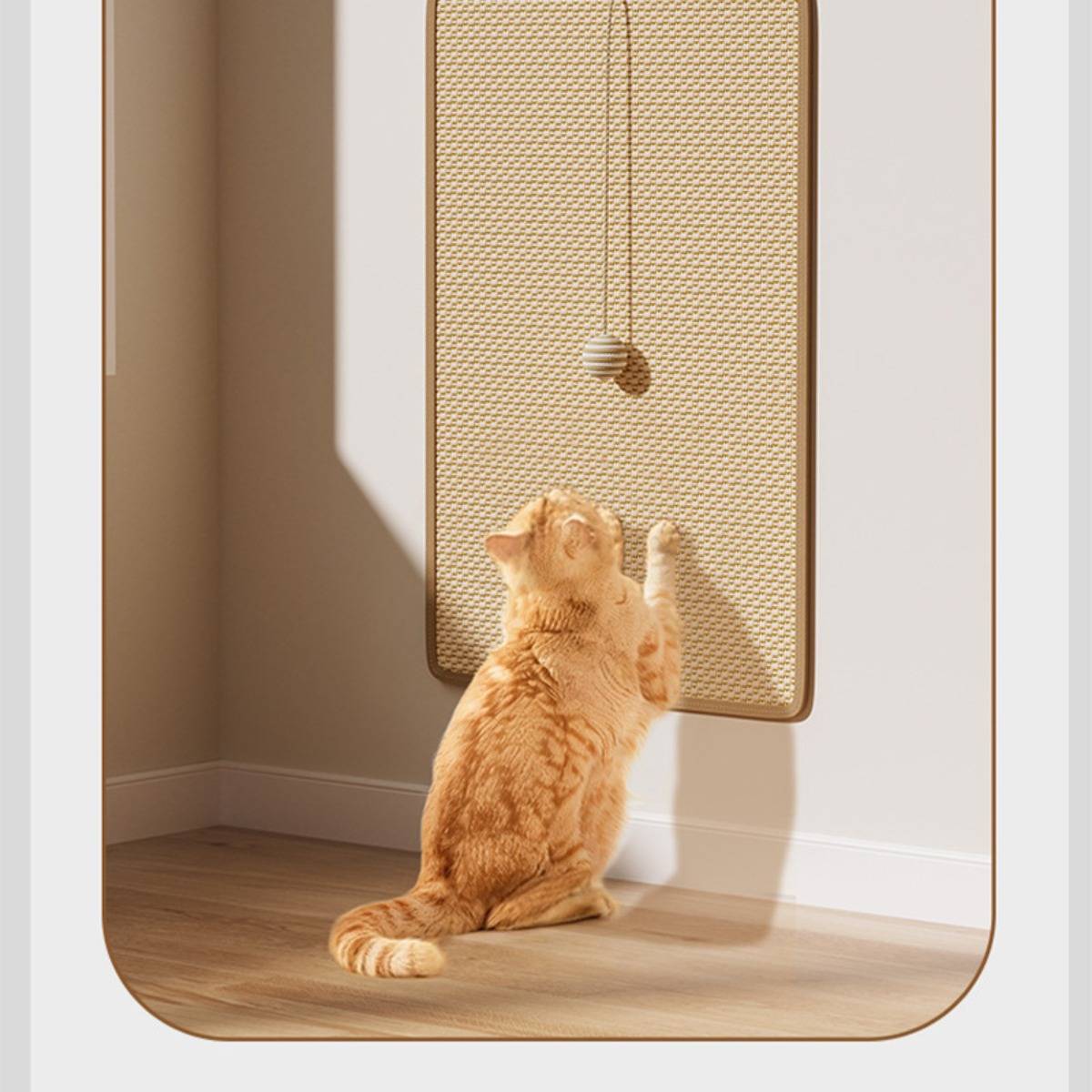 Orange cat kratzt an einem wandmontierten Sisalscratching-Panel in einem sonnigen Raum.