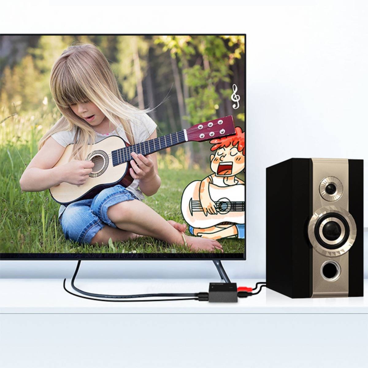 Fernseher, auf dem ein Mädchen zeigt, das draußen Gitarre spielt, verbunden durch Kabel mit einem Lautsprecher auf der rechten Seite.