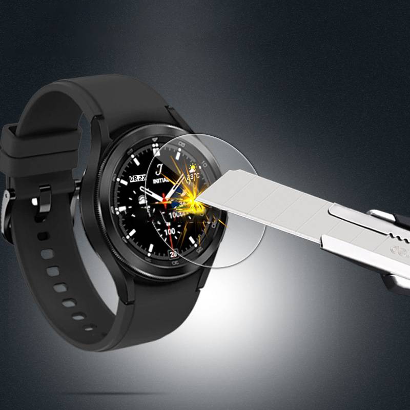 Ein Smartwatch-Bildschirm wird mit einer Cuttermesserklinge zerkratzt oder geschnitten, wobei Beschädigungen und die Zerbrechlichkeit des Displays deutlich werden.