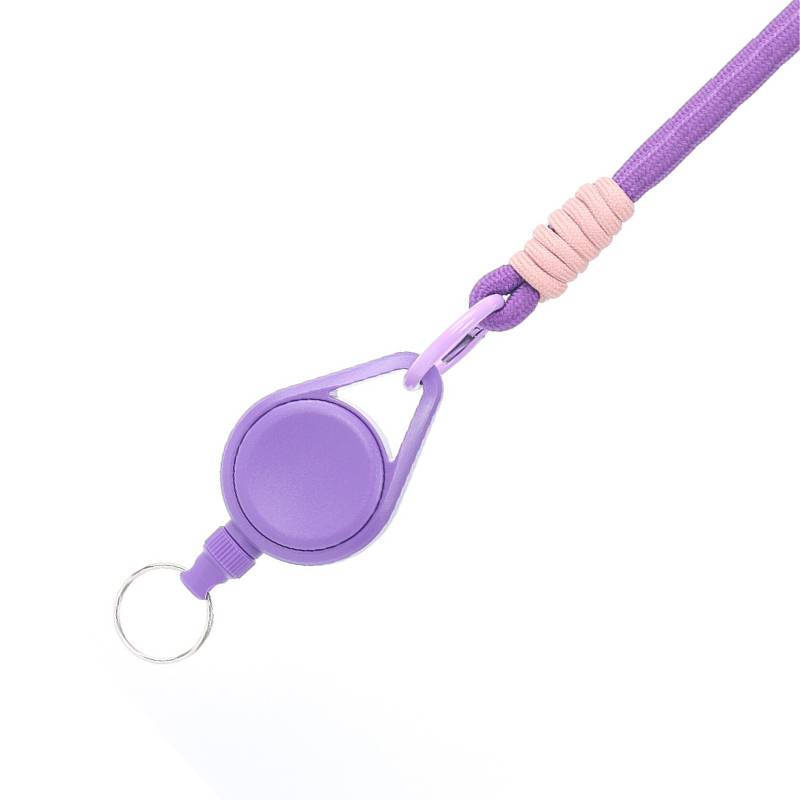 Violette ausziehbare Schlüsselkette oder Ausweisrolle mit Ringclip und rosa Wicklung in der Nähe des Riemens, isoliert auf weißem Hintergrund.