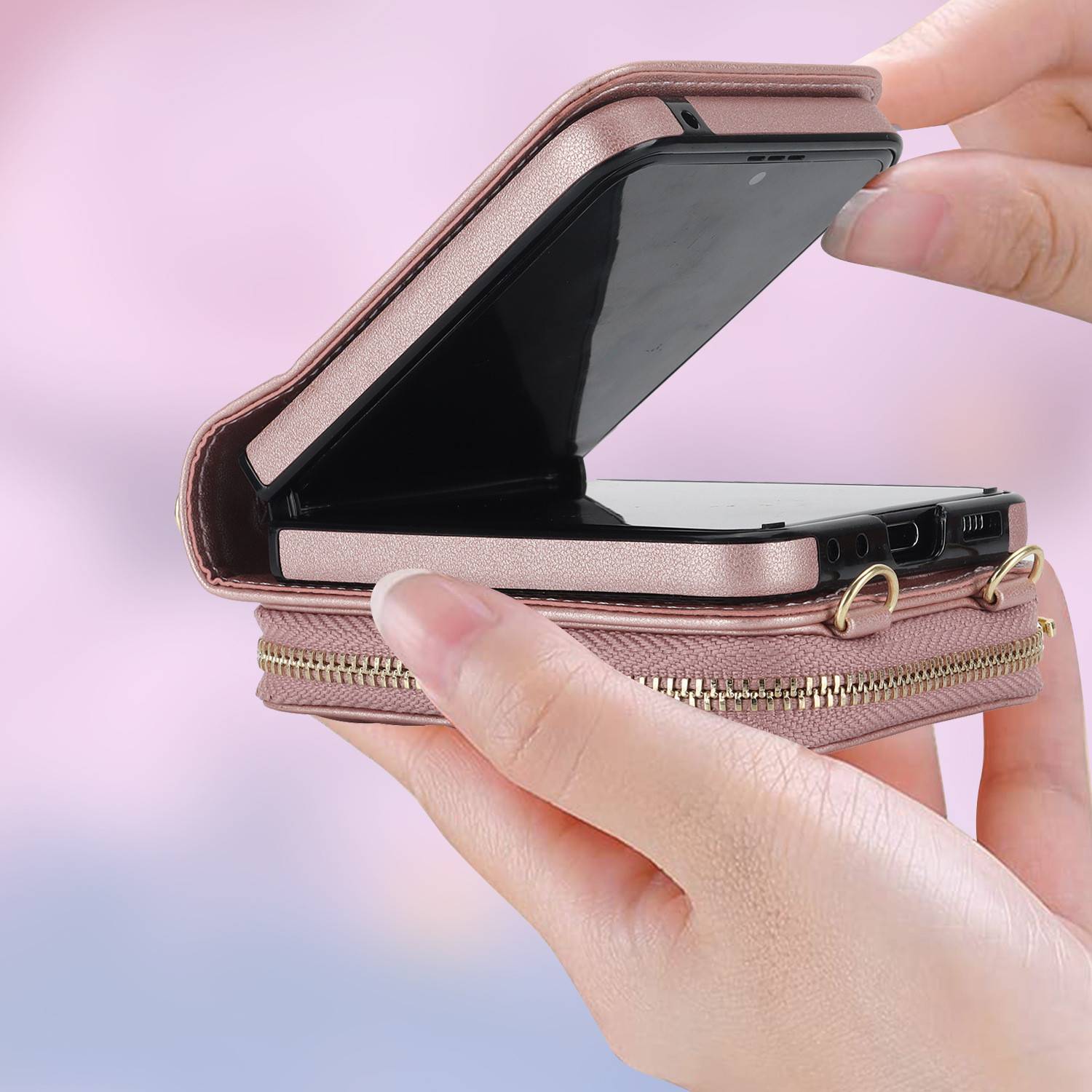Hände halten eine rosa Telefongeldbörsen-Handyhülle mit einem Smartphone, das teilweise im Inneren geöffnet ist und das faltbare, reißverschlussgesicherte Design der Hülle zeigt.