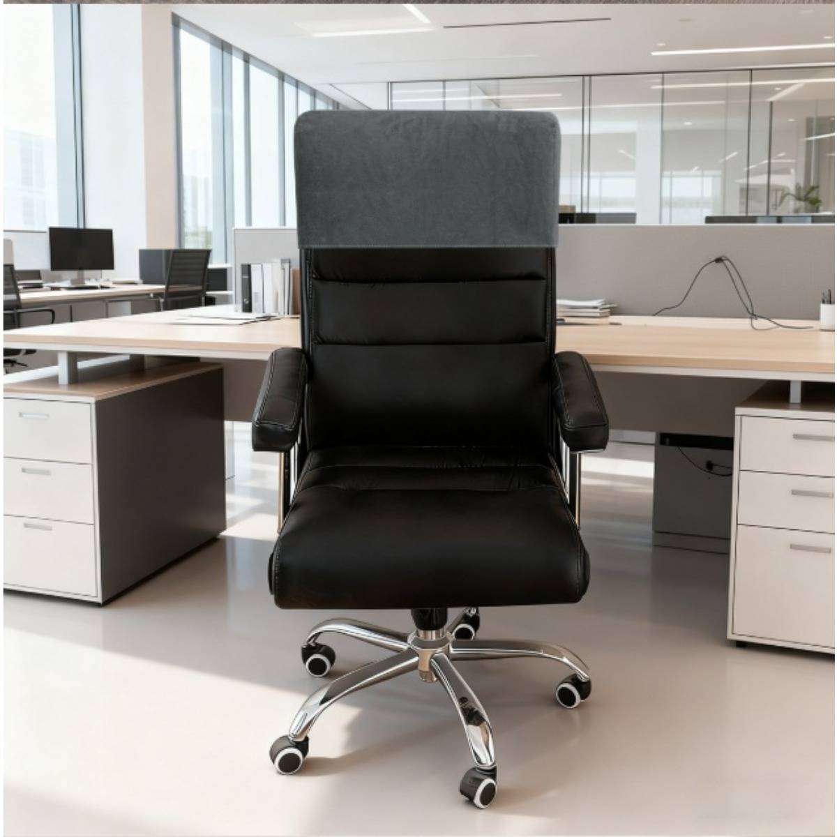 Schwarzer Bürostuhl in der Mitte eines modernen, leeren Arbeitsbereichs mit Schreibtischen, Computern und Glaswandtrennwänden im Hintergrund.