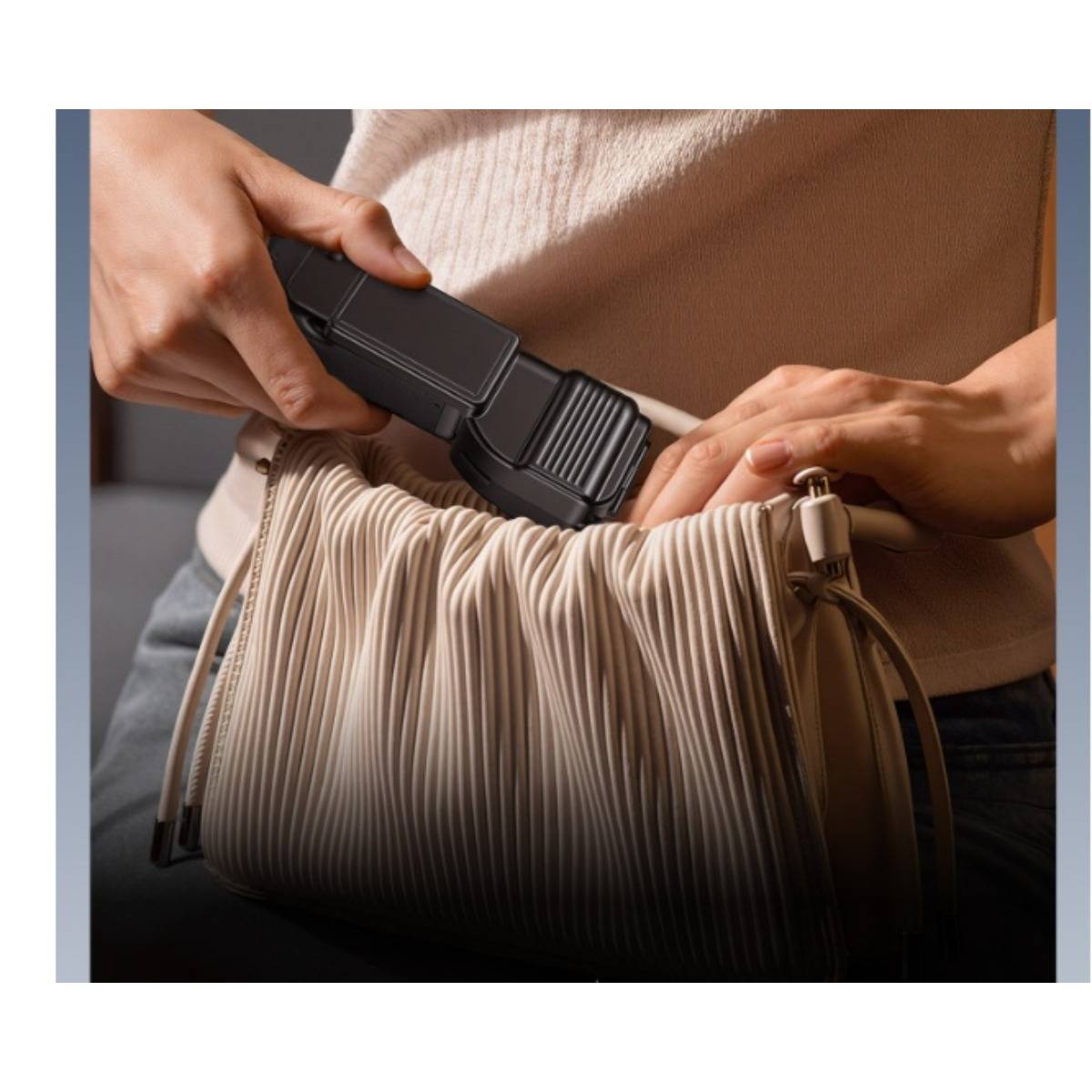 Eine Person verwendet einen tragbaren Dampfreiniger auf einer beigen gefalteten Tasche oder einem Kleidungsstück und glättet Falten.